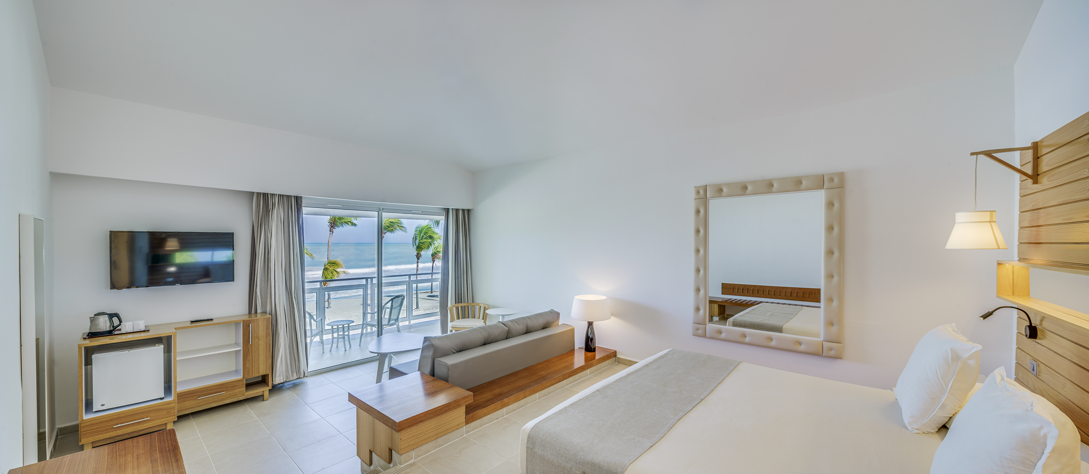 a room with a bed and a mirror and a table