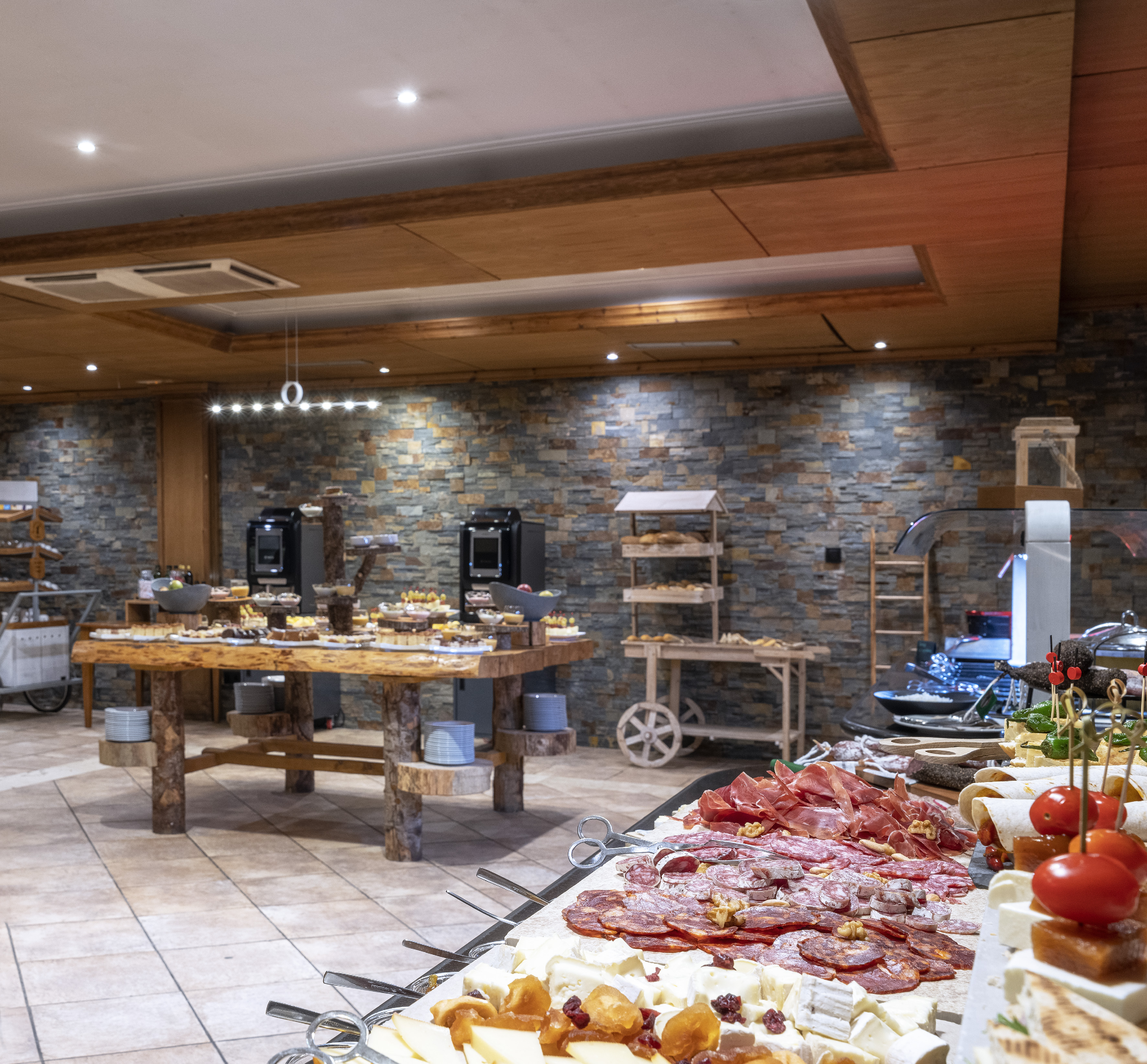Rustic hotel buffet with cheese, charcuterie, appetizers, and desserts.