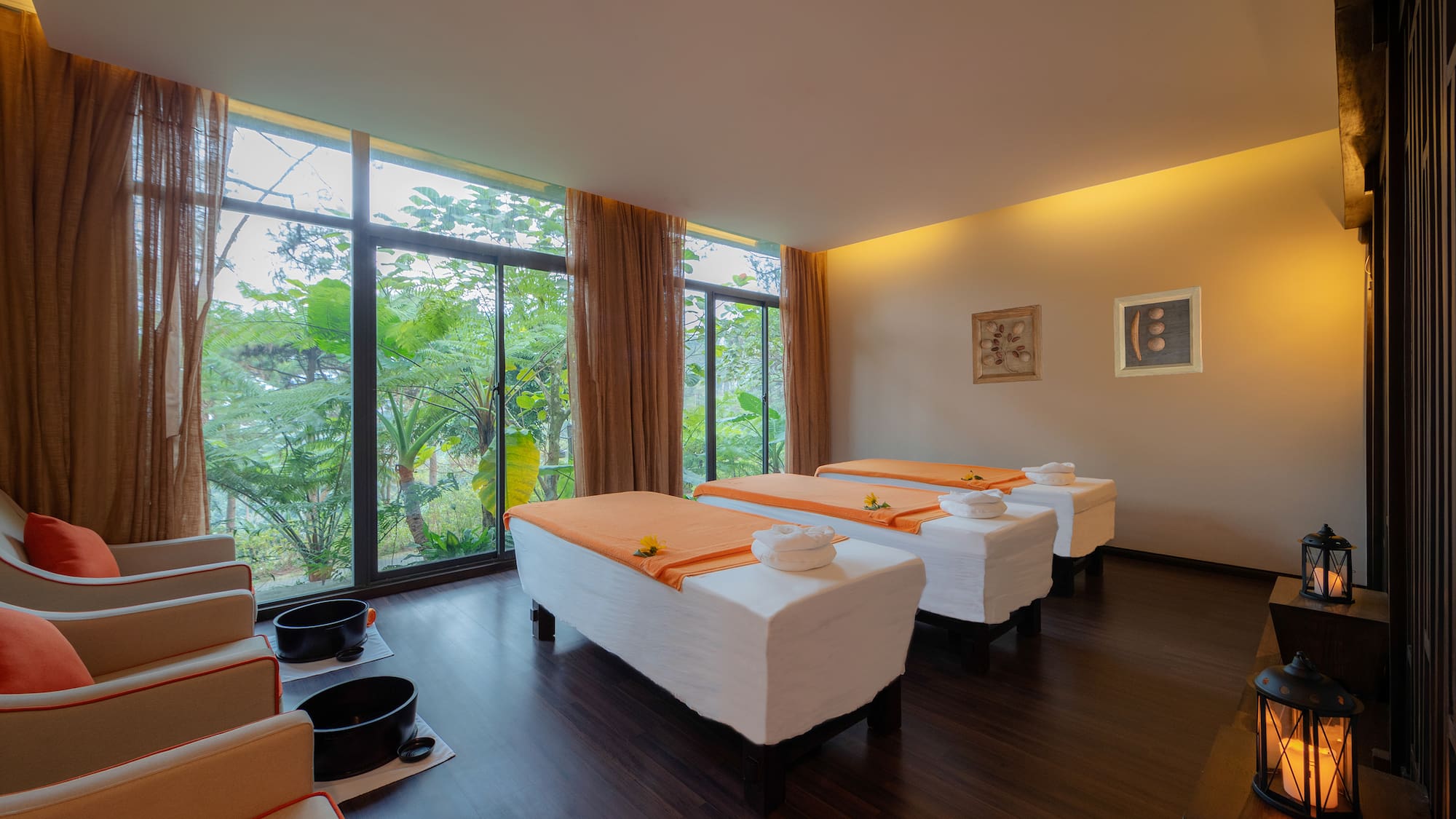 Spa room with massage beds, foot spa chairs, and tropical window views.