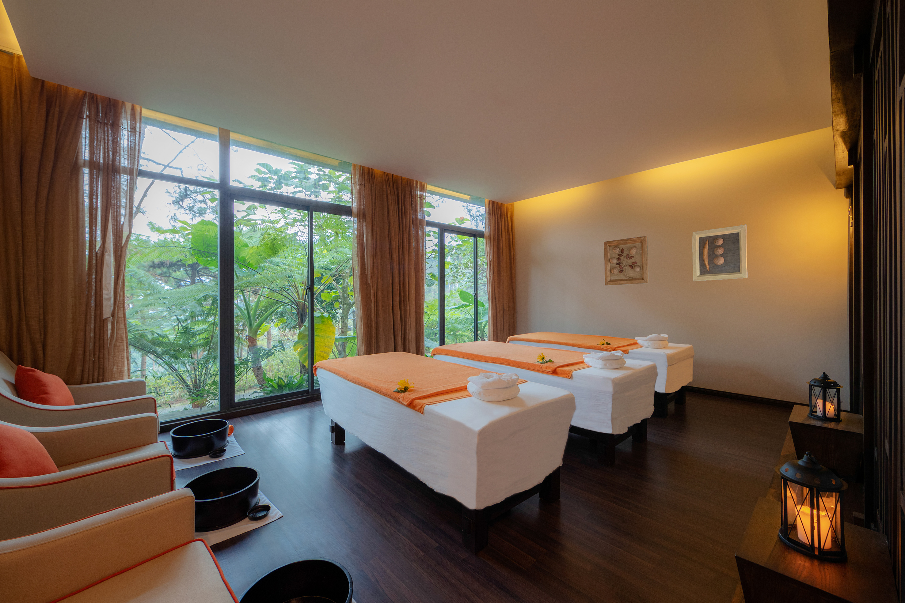 Spa room with massage beds, foot spa chairs, and tropical window views.