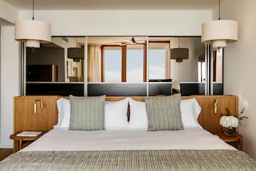 a bed with pillows and a mirror above it