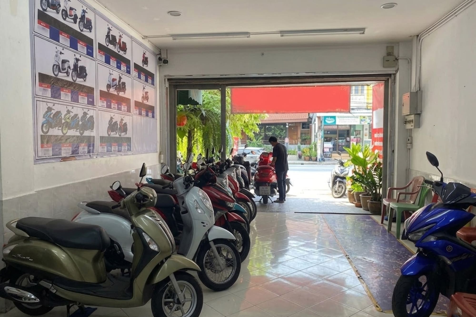Motorbike showroom: new scooters on display, person working at entrance.