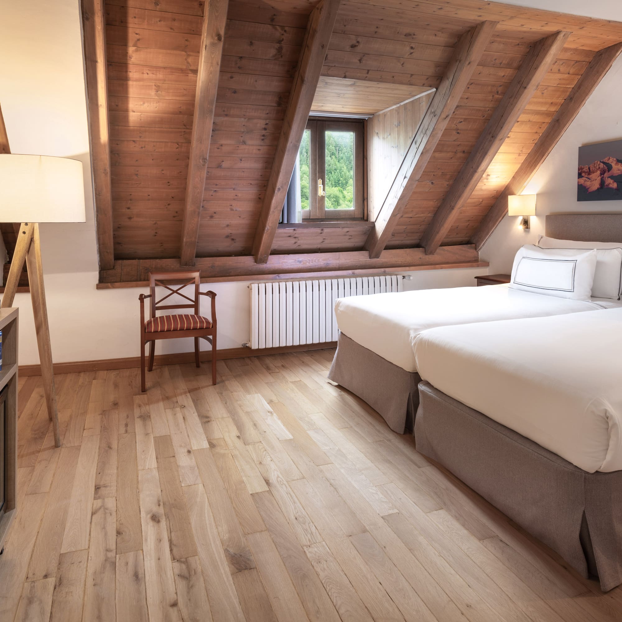 a room with two beds and a wood floor