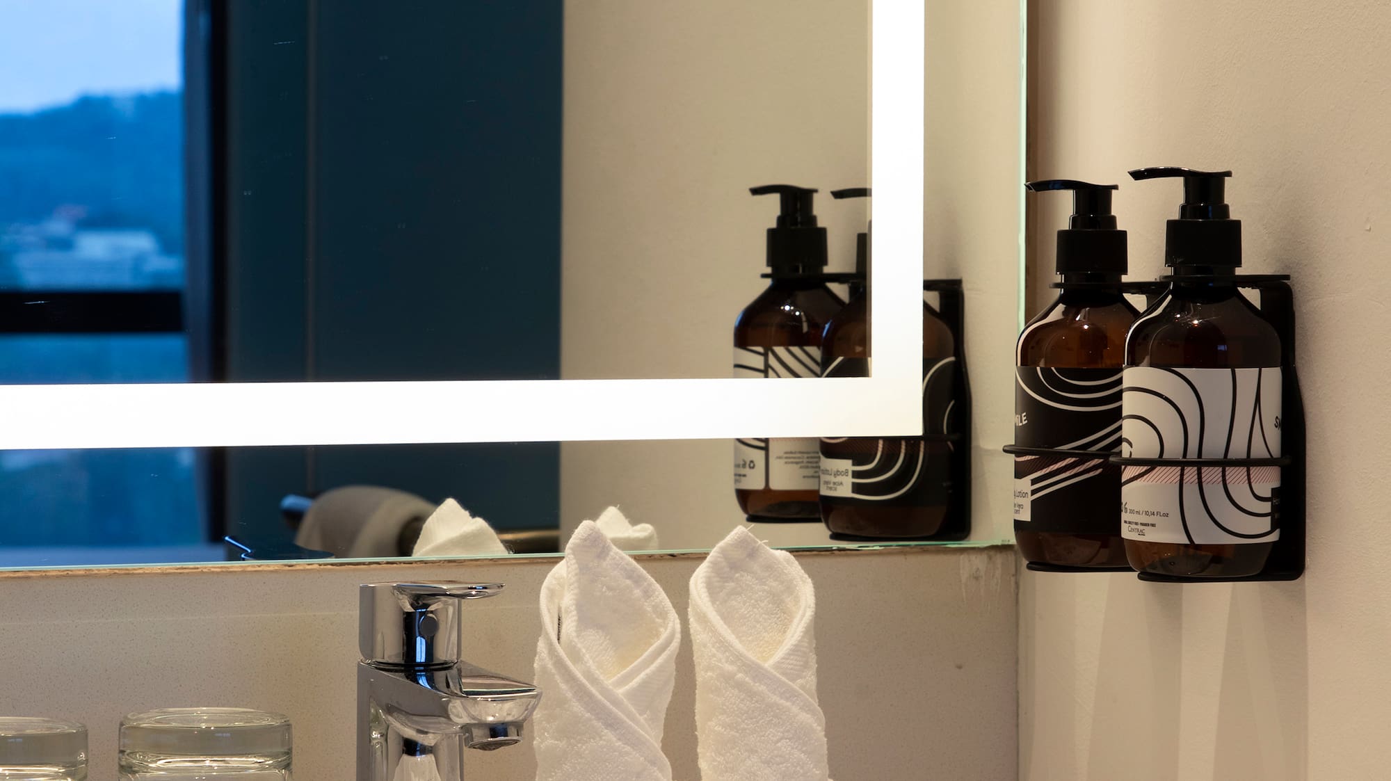 a bathroom sink with a mirror and towels