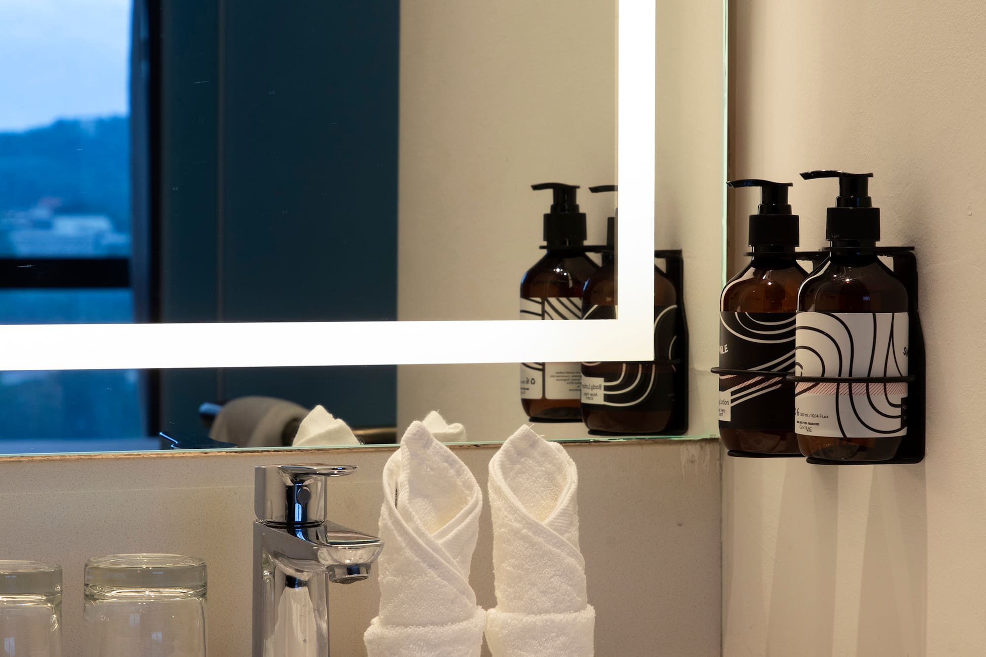 a bathroom sink with a mirror and towels