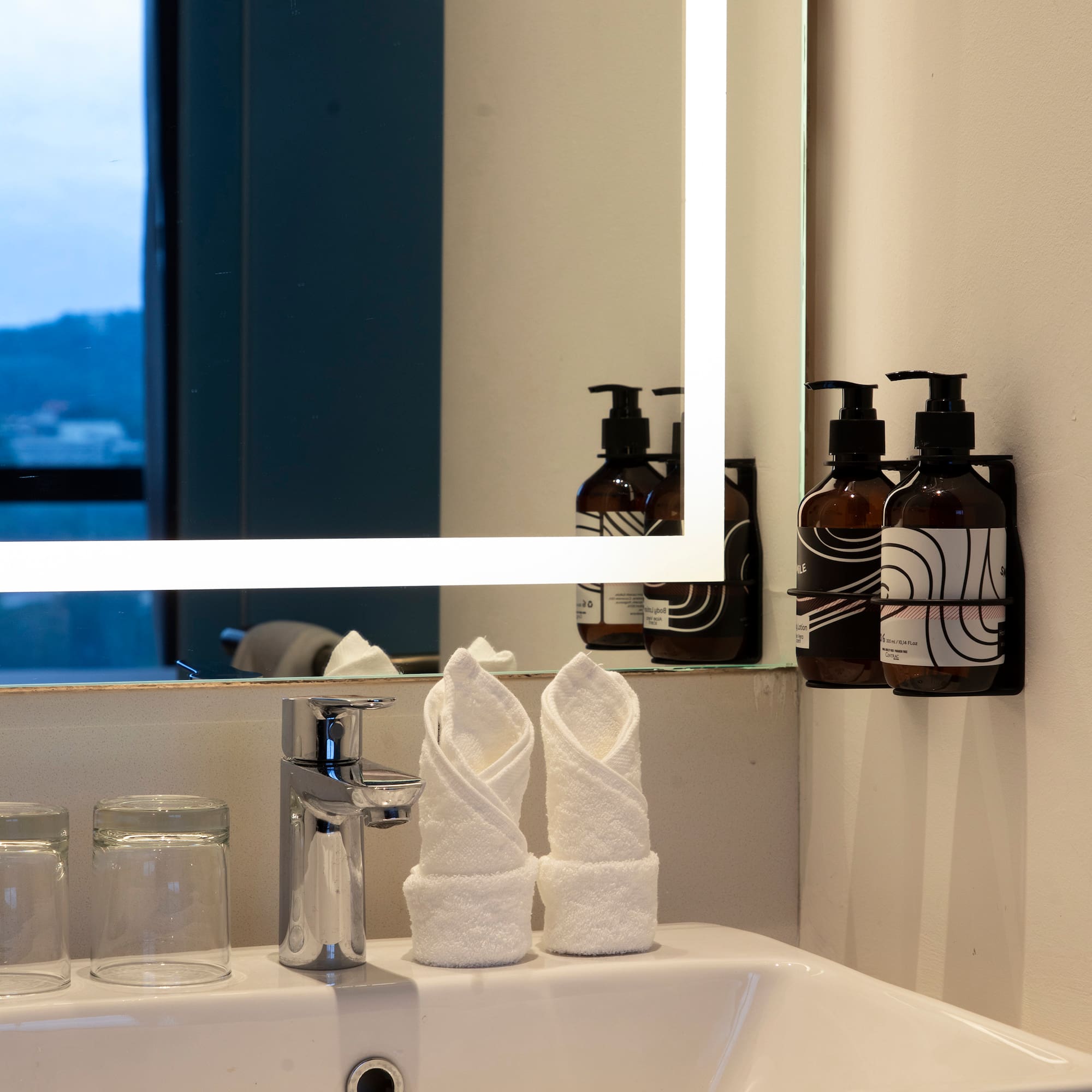 a bathroom sink with a mirror and towels
