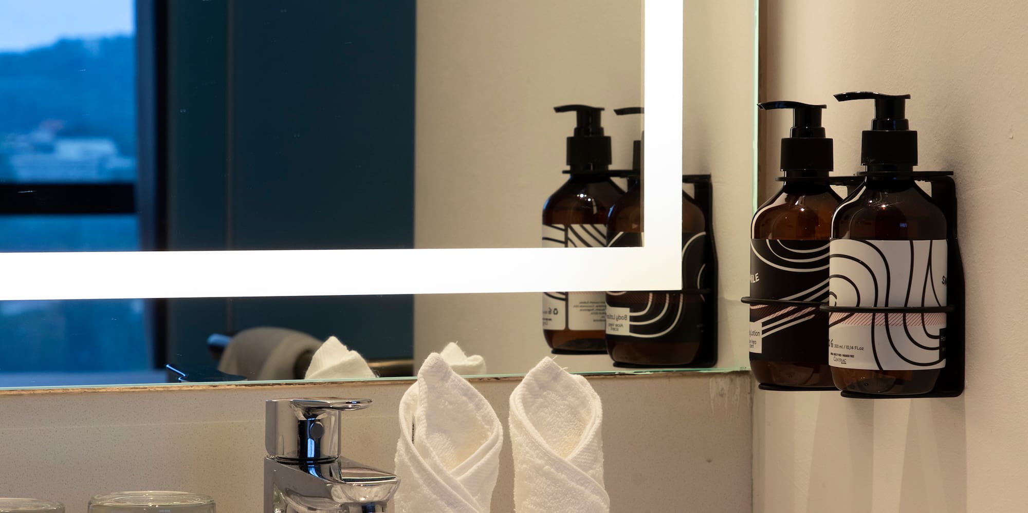 a bathroom sink with a mirror and towels