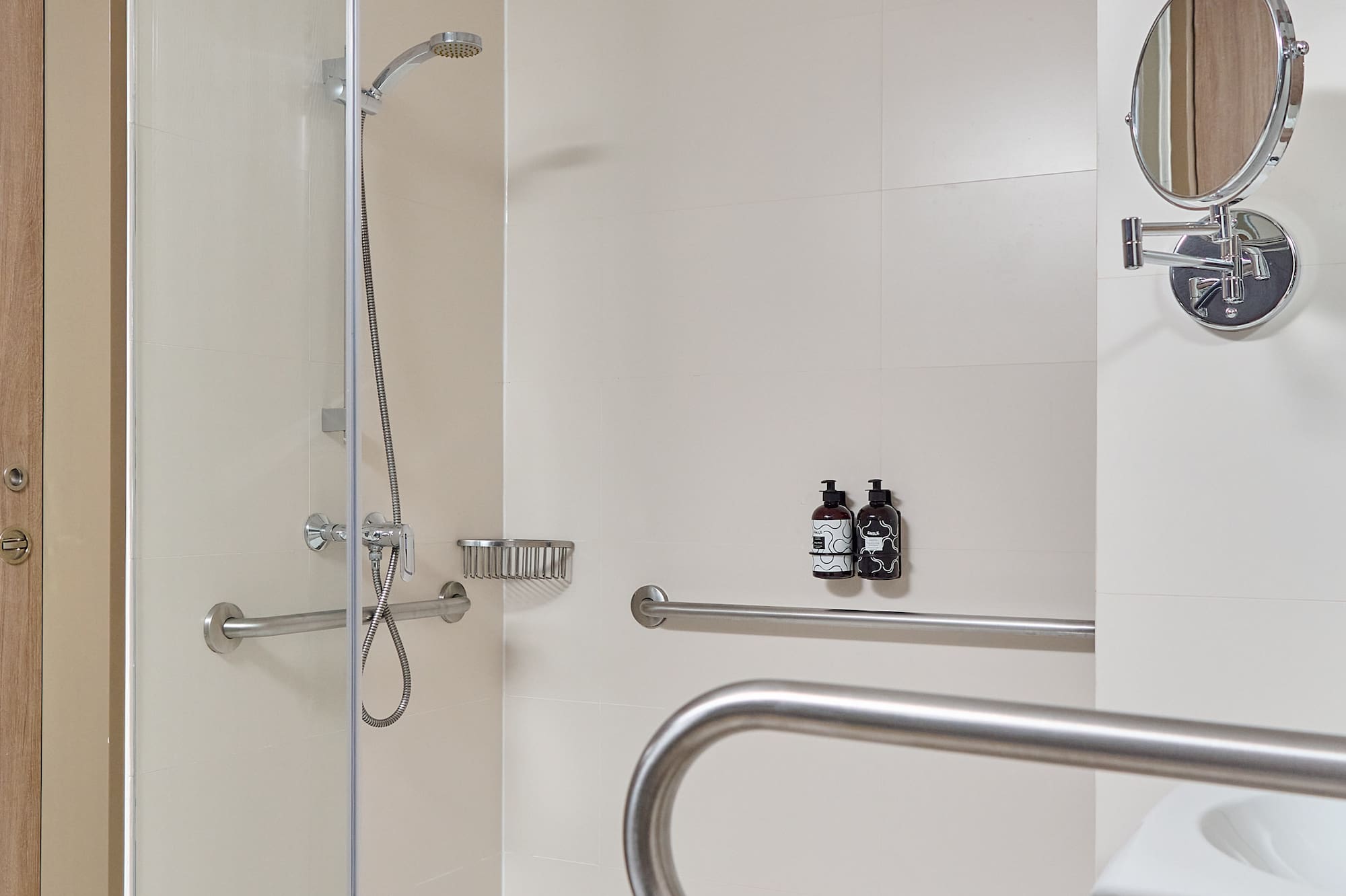 a shower with a mirror and a round mirror