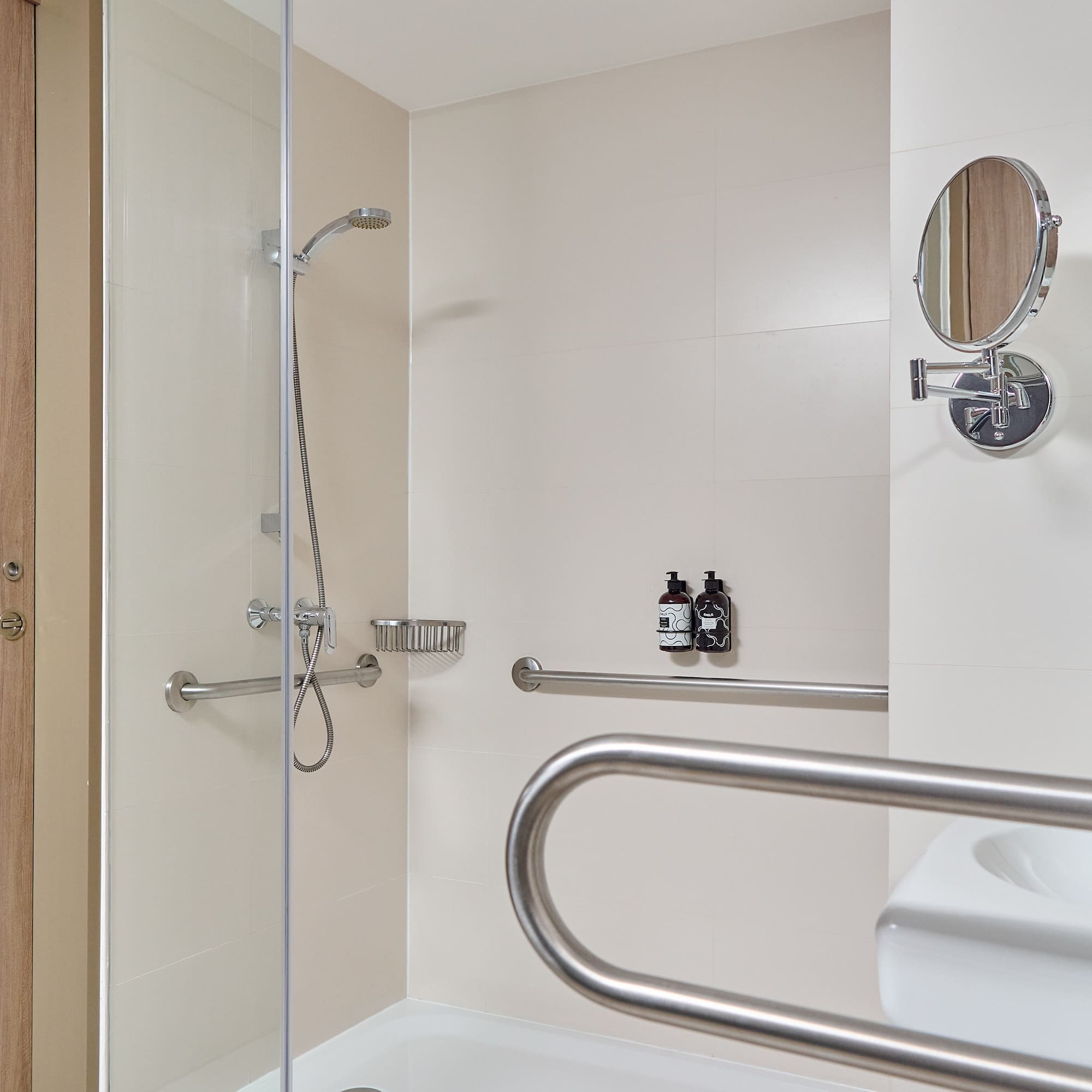 a shower with a mirror and a round mirror