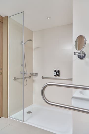 a shower with a mirror and a round mirror