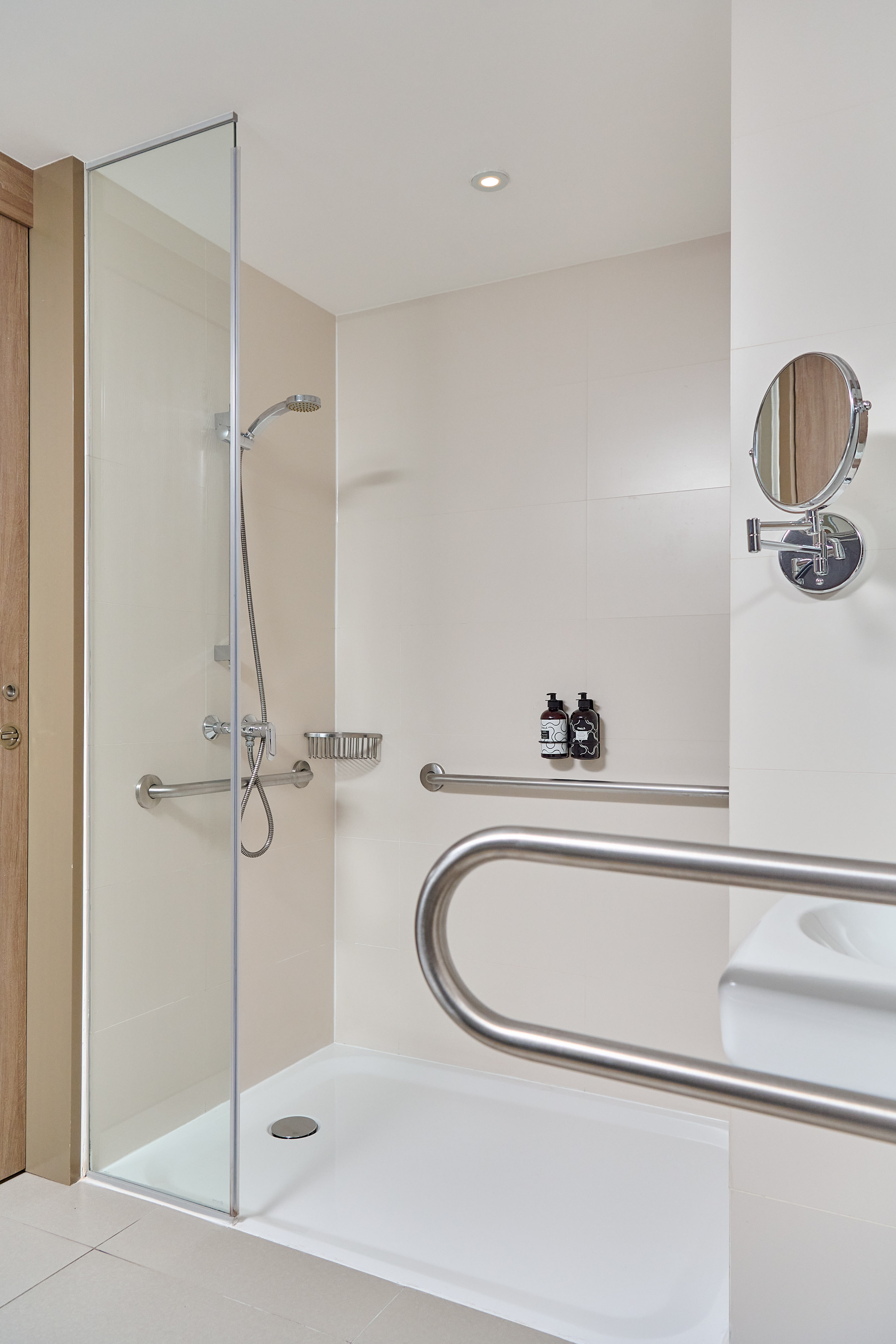 a shower with a mirror and a round mirror