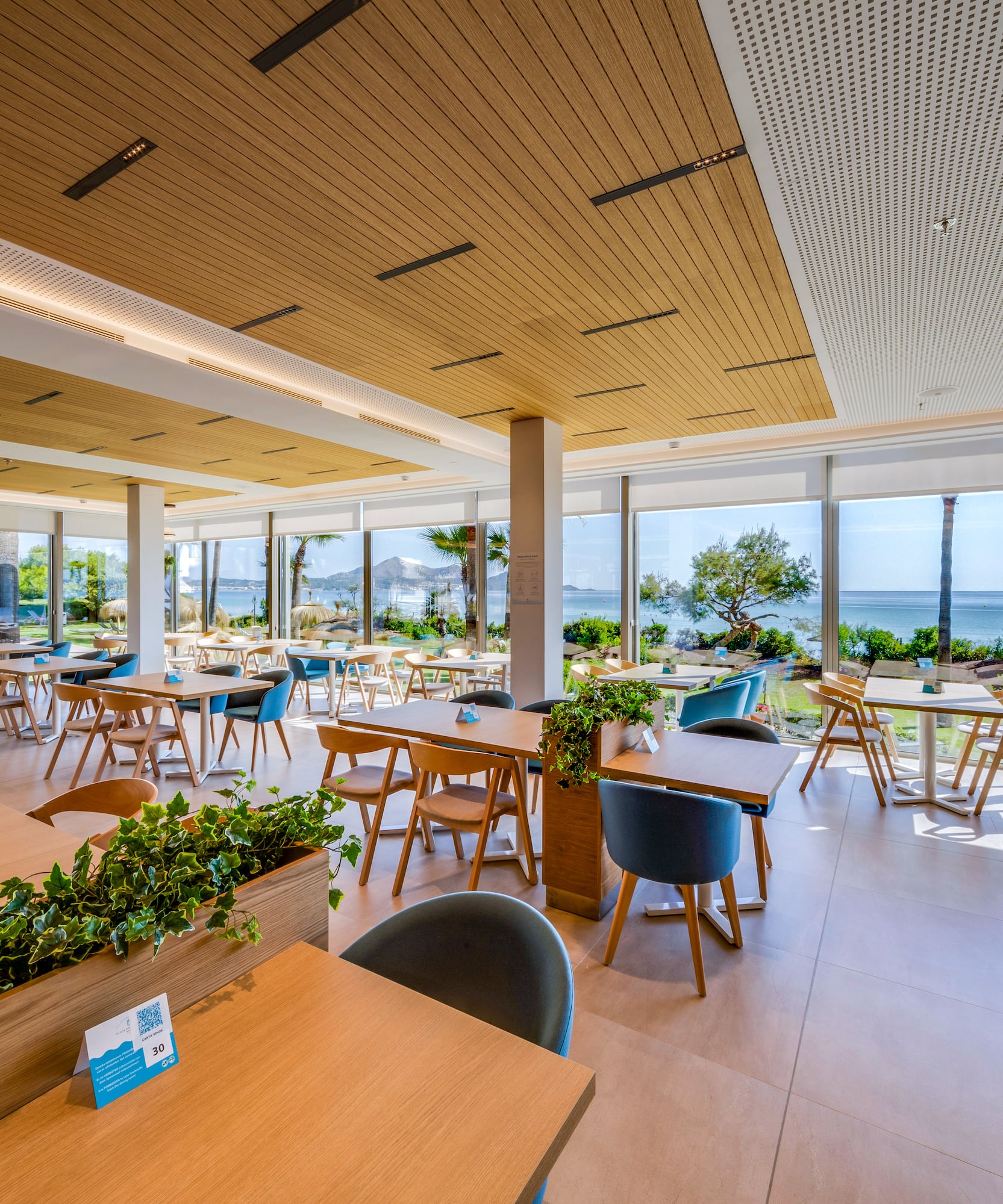 a room with tables and chairs and plants