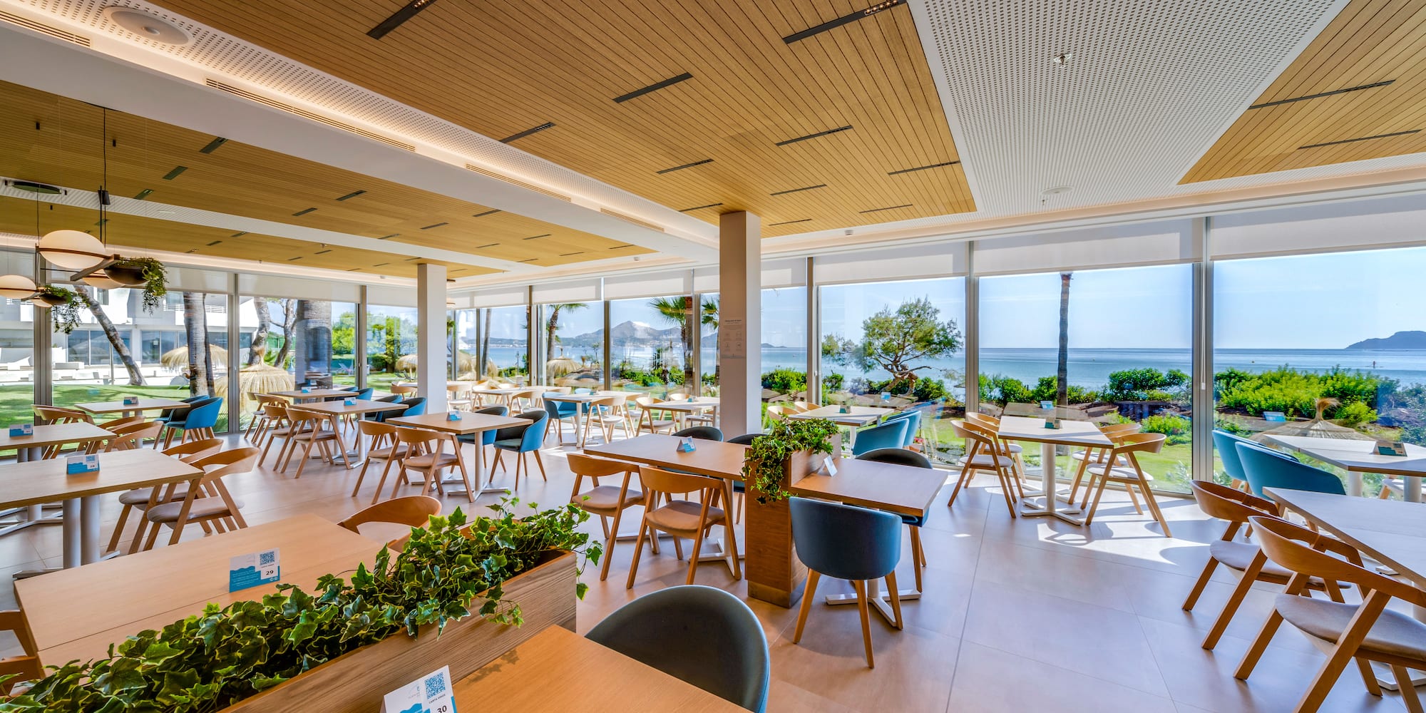 a room with tables and chairs and plants
