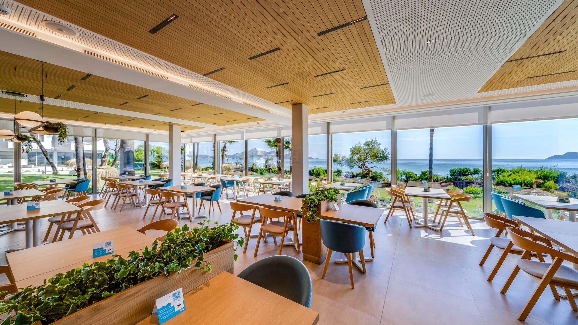 a room with tables and chairs and plants