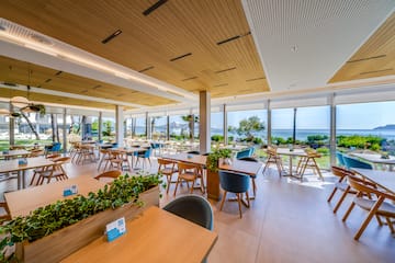a room with tables and chairs and plants