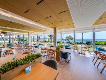 a room with tables and chairs and plants