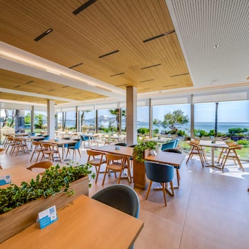 a room with tables and chairs and plants