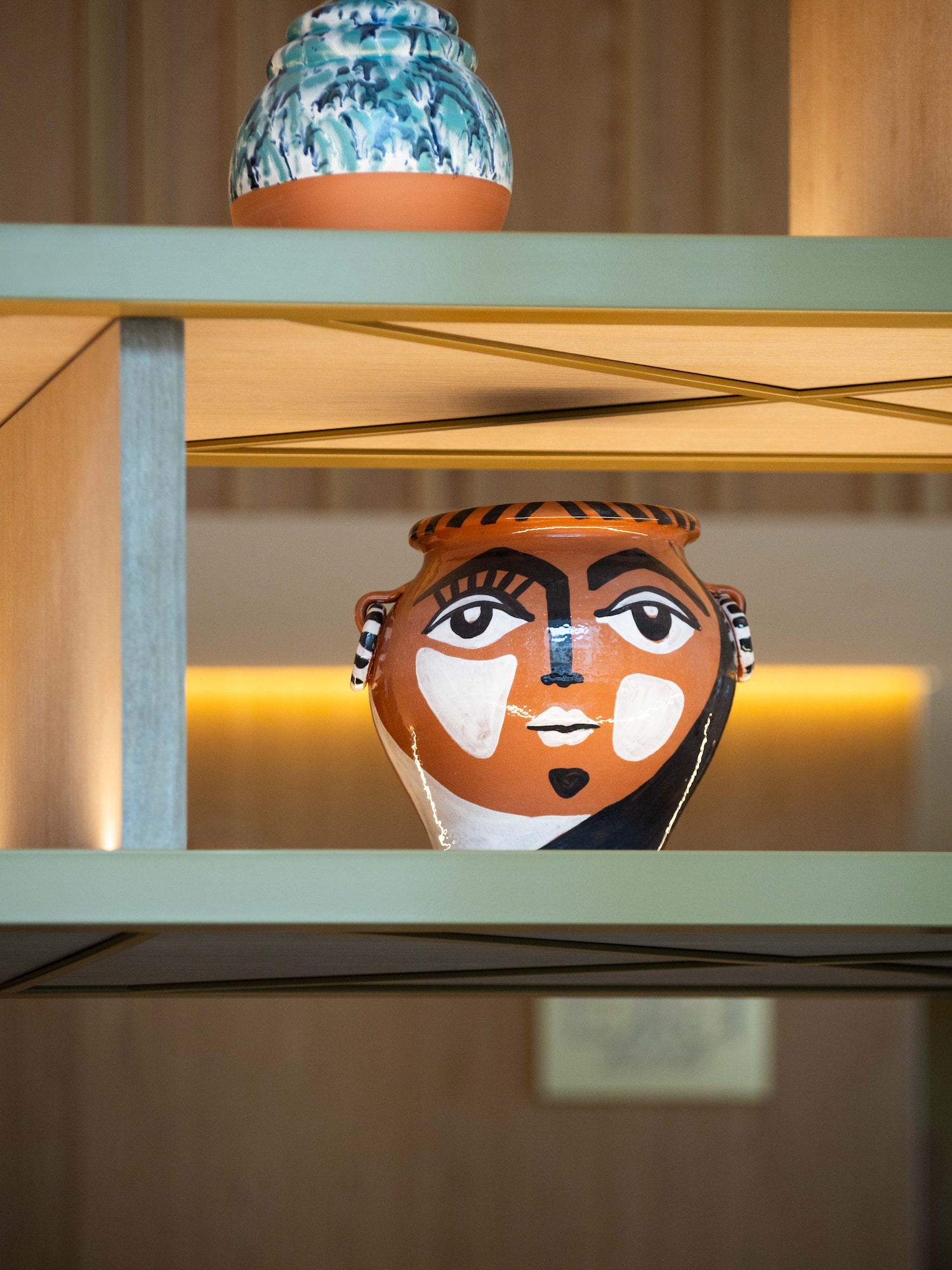 a ceramic pot on a shelf