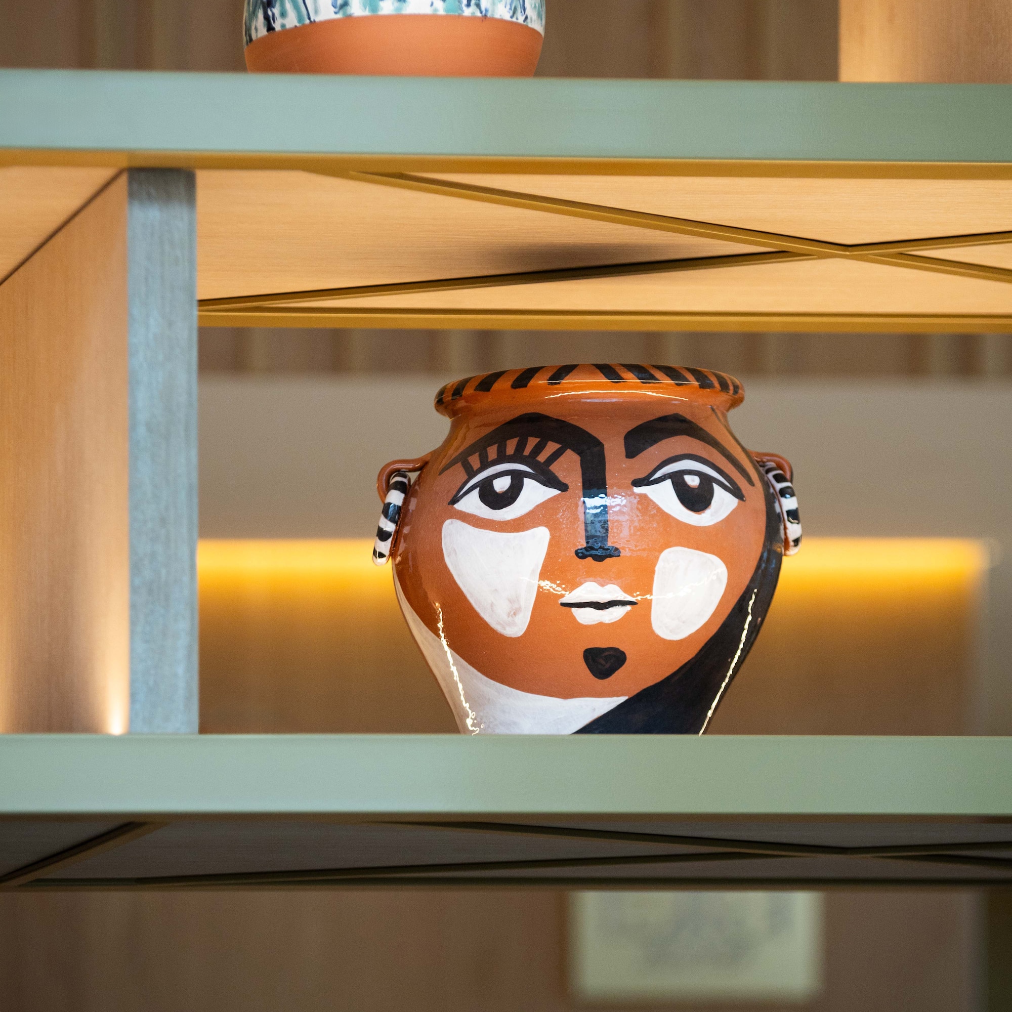 a ceramic pot on a shelf