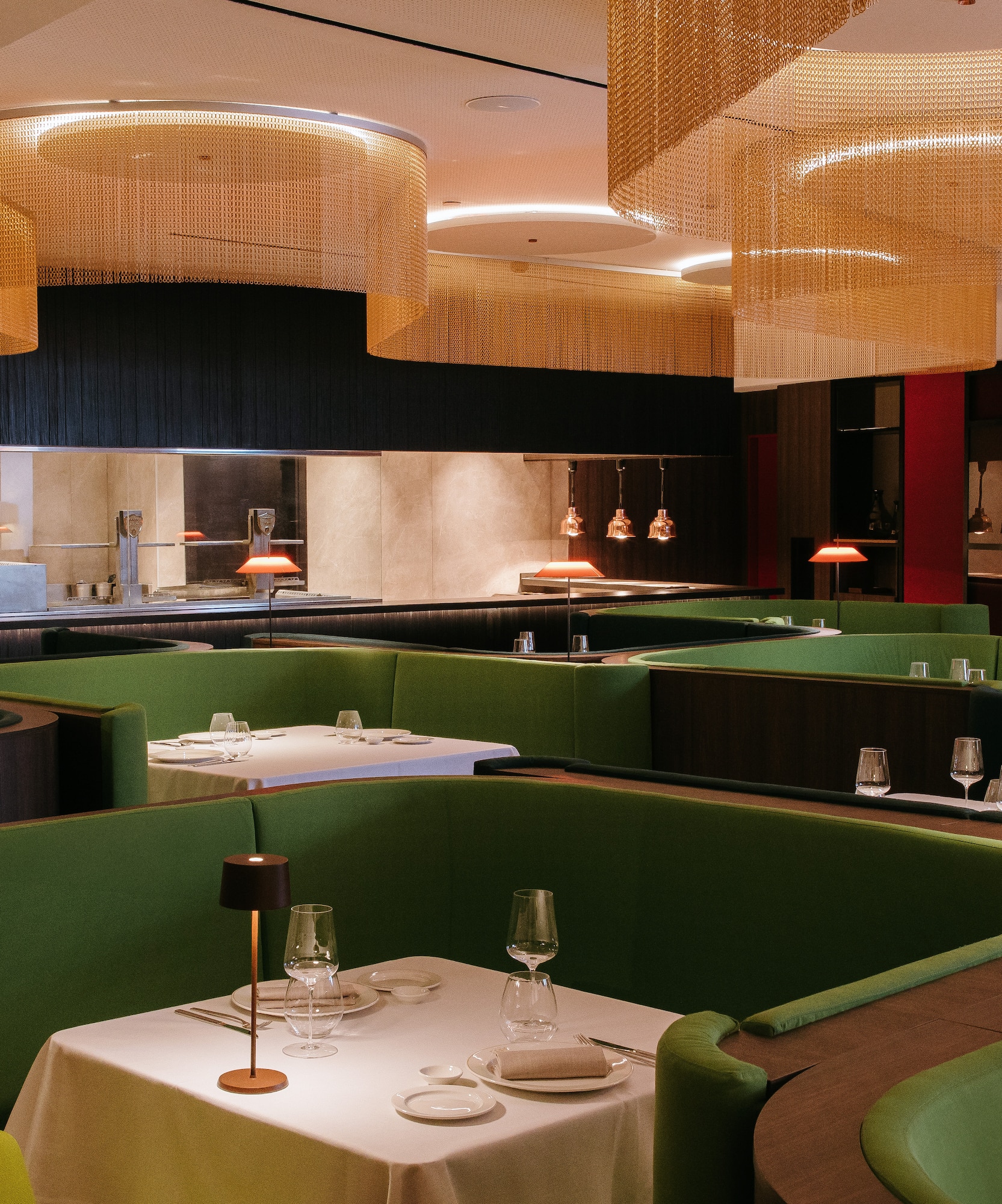 a restaurant with green booth seating and green couches