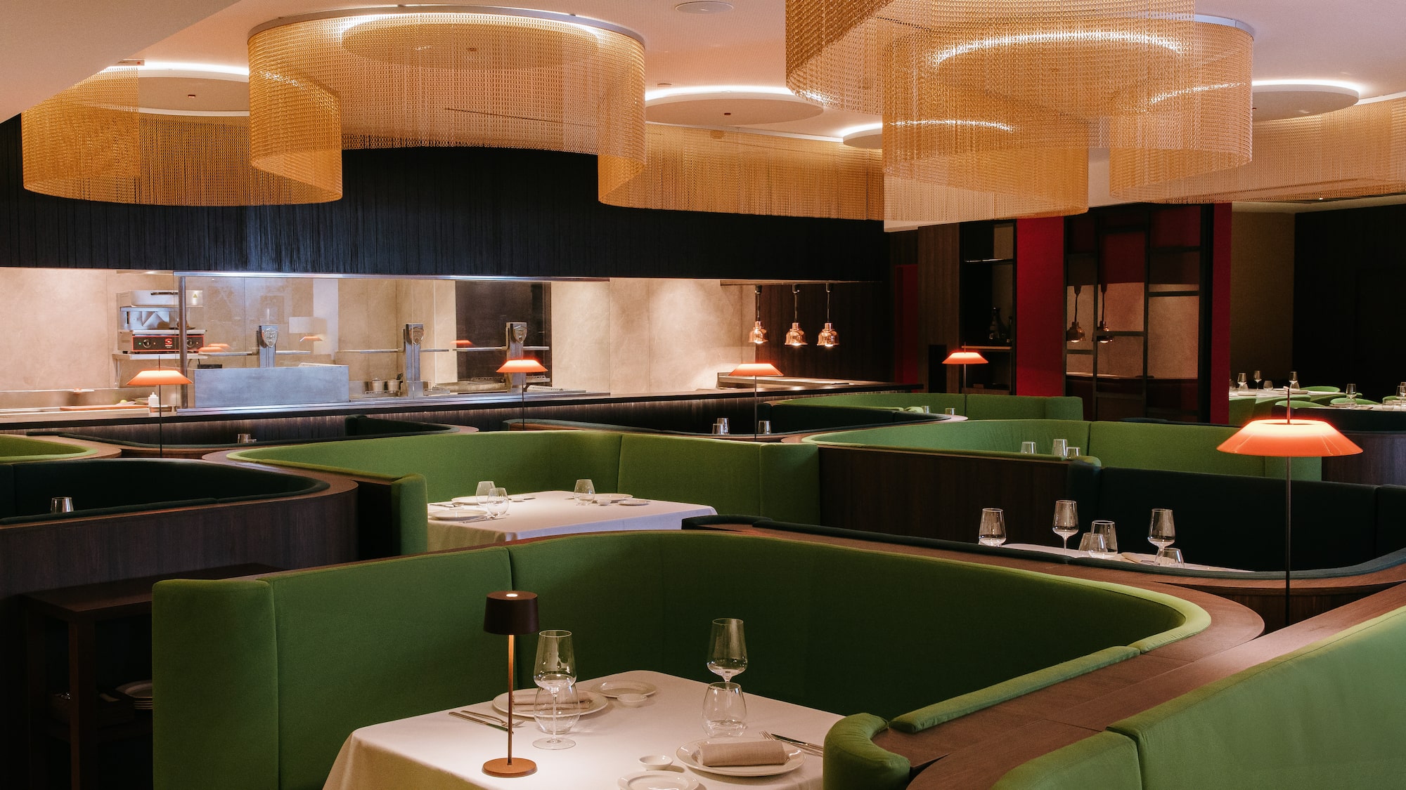 a restaurant with green booth seating and green couches