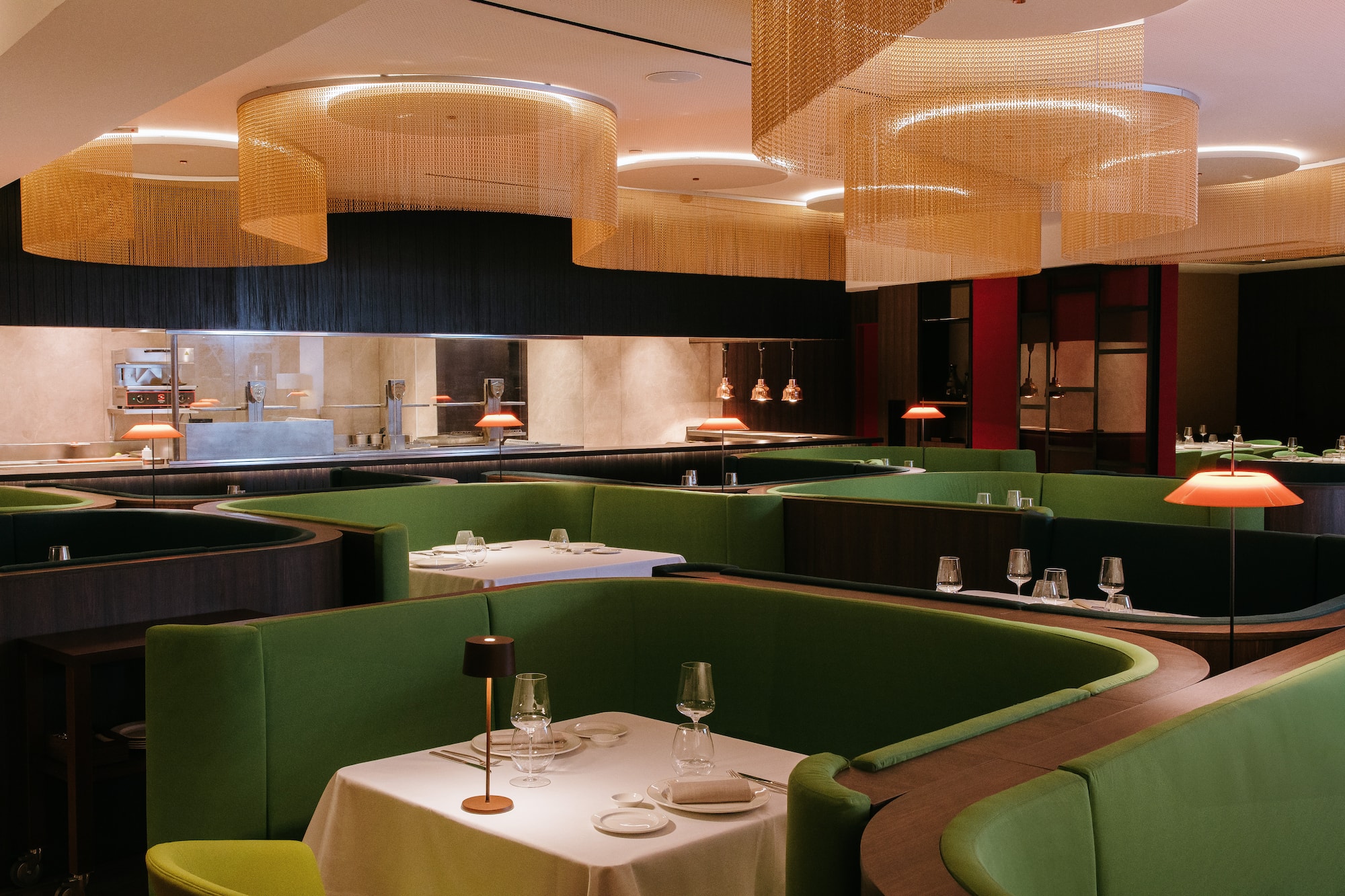 a restaurant with green booth seating and green couches