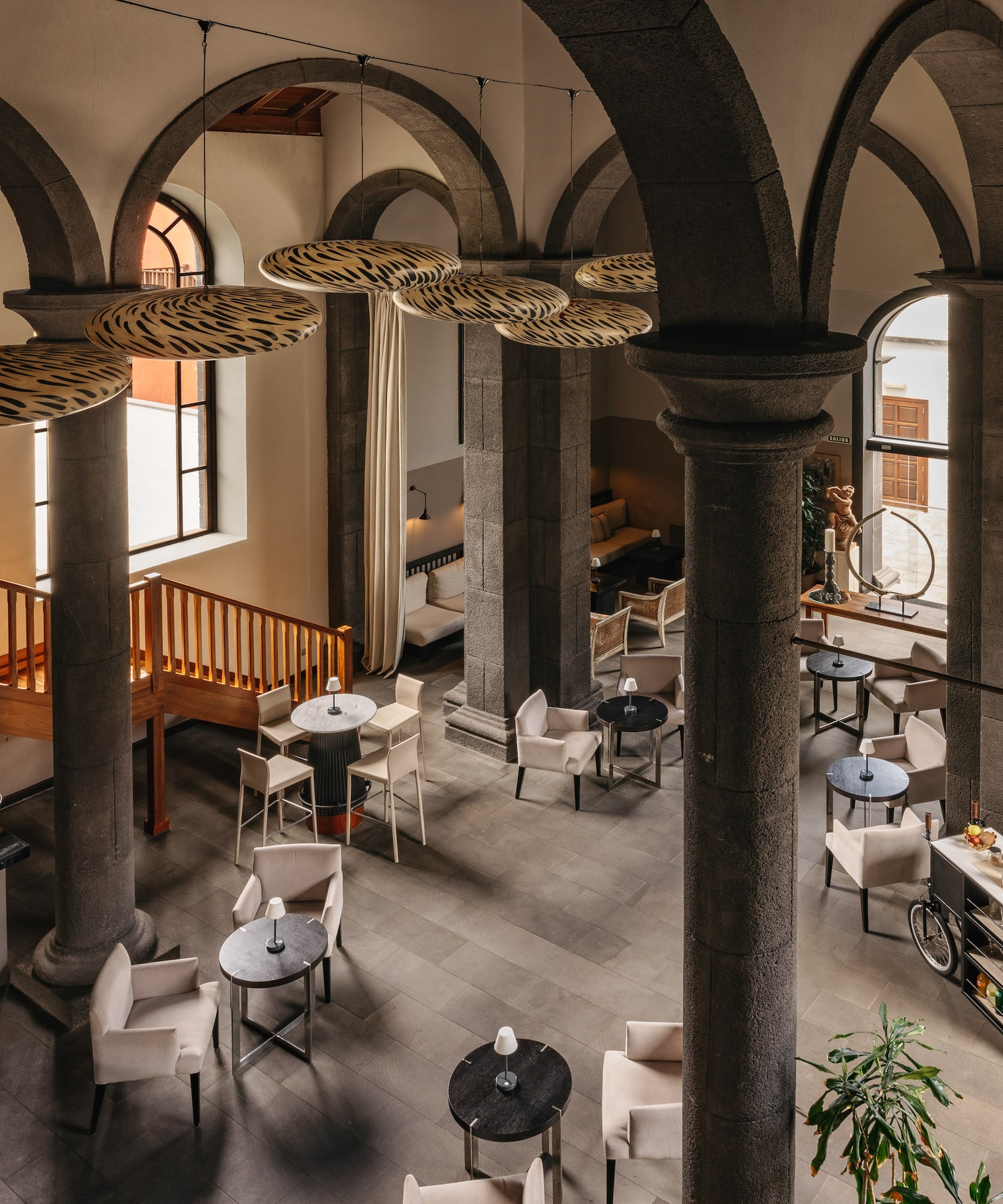 Hotel lounge with grand stone arches, modern lighting, and comfortable seating.