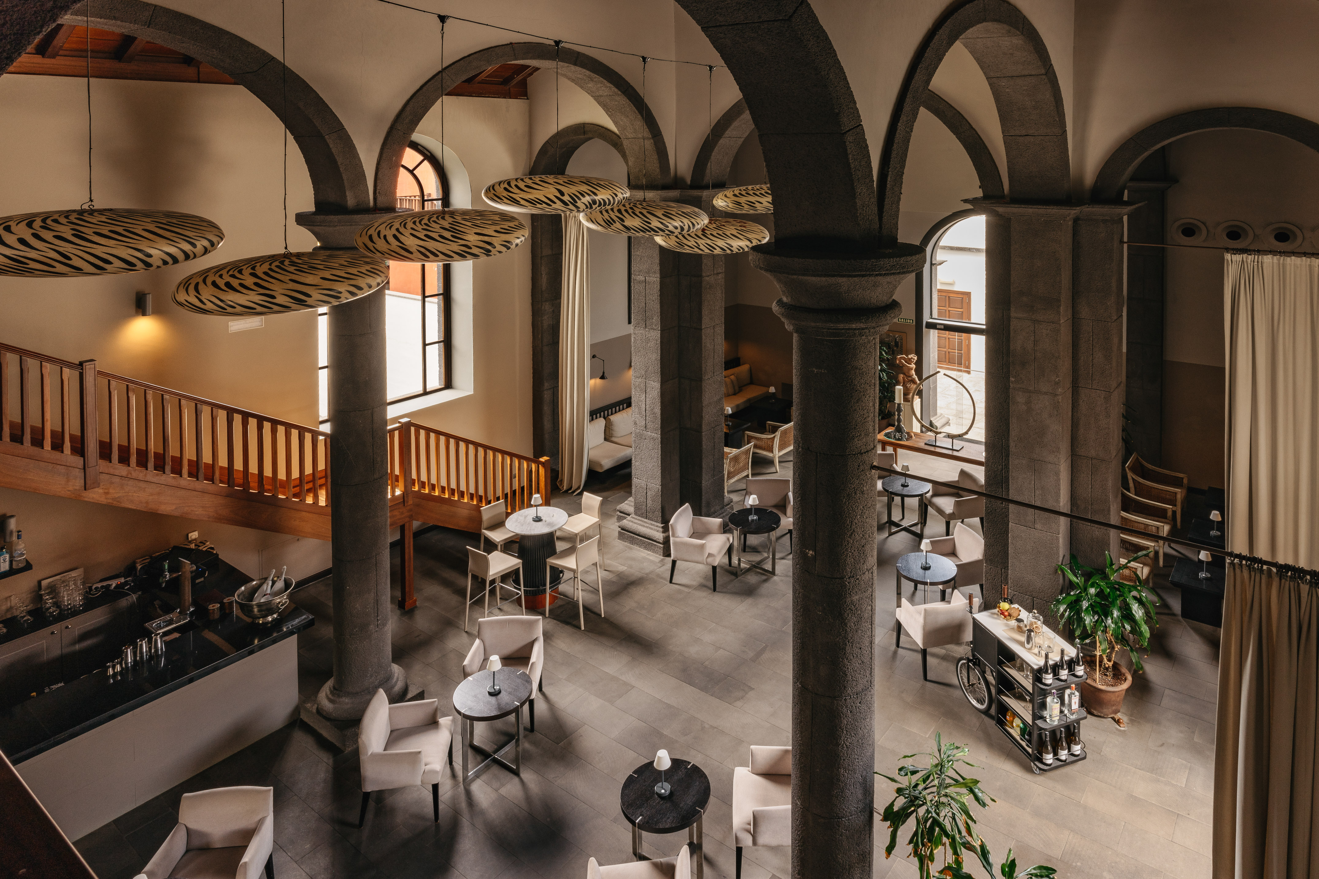 Hotel lounge with grand stone arches, modern lighting, and comfortable seating.
