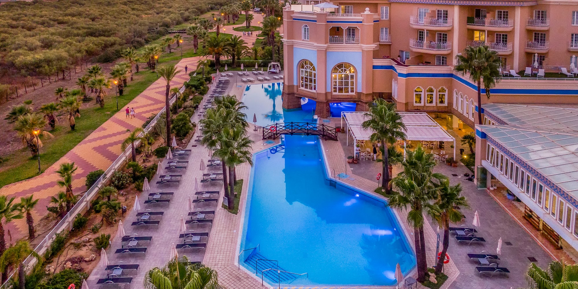a swimming pool and a building with palm trees