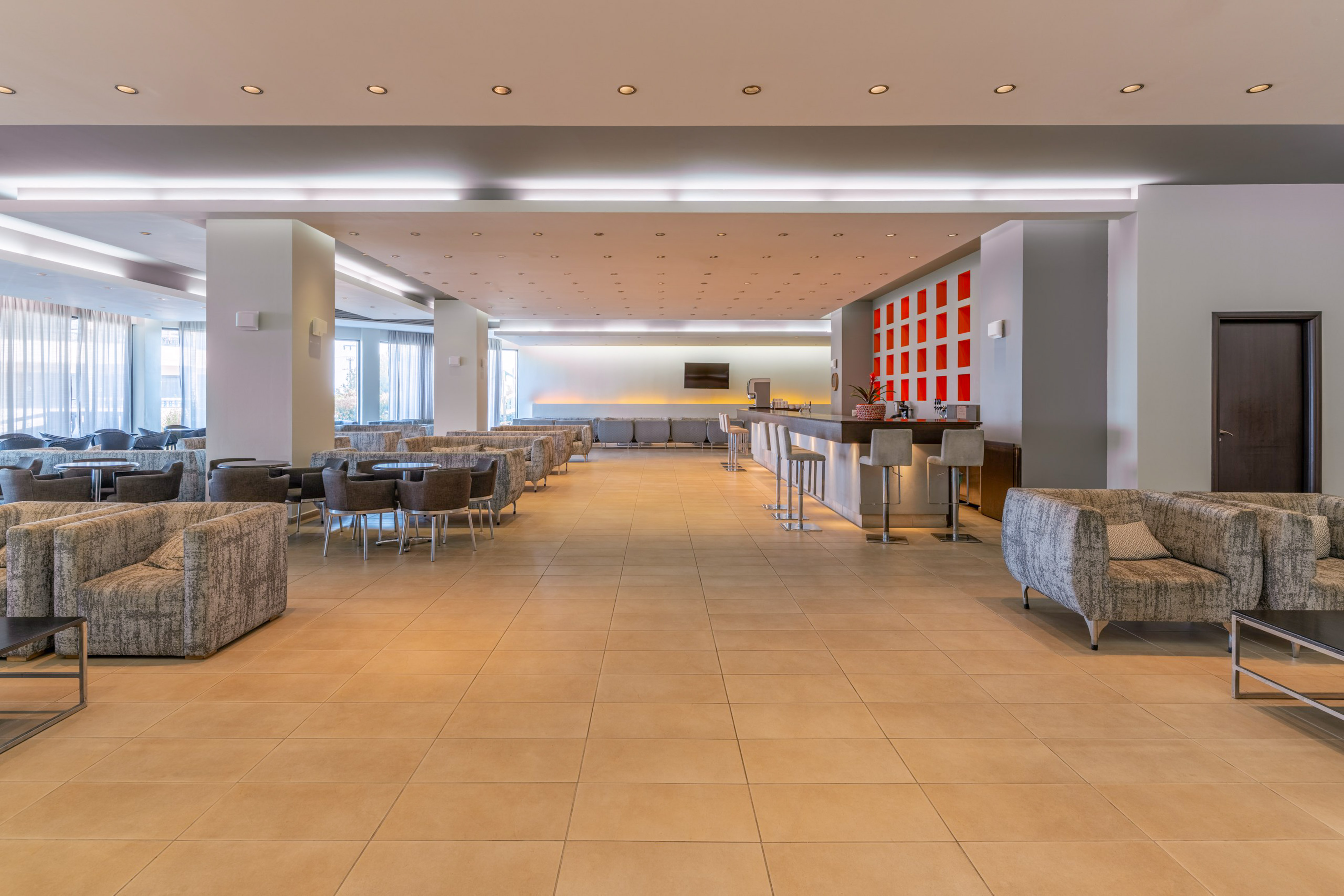 Spacious hotel lounge with modern bar, comfortable seating, and bright lighting.
