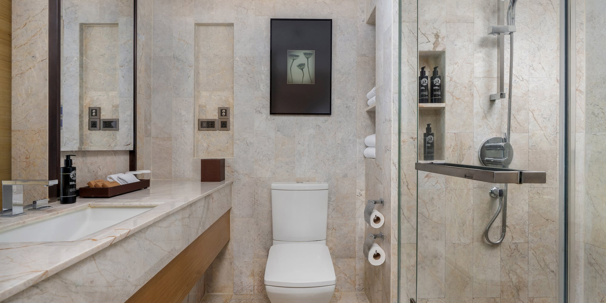 Modern marble bathroom featuring a white toilet, sink vanity, and glass shower. - Guest Room - The Hotel Bangkok Sukhumvit 26 Affiliated by Meliá, Bangkok