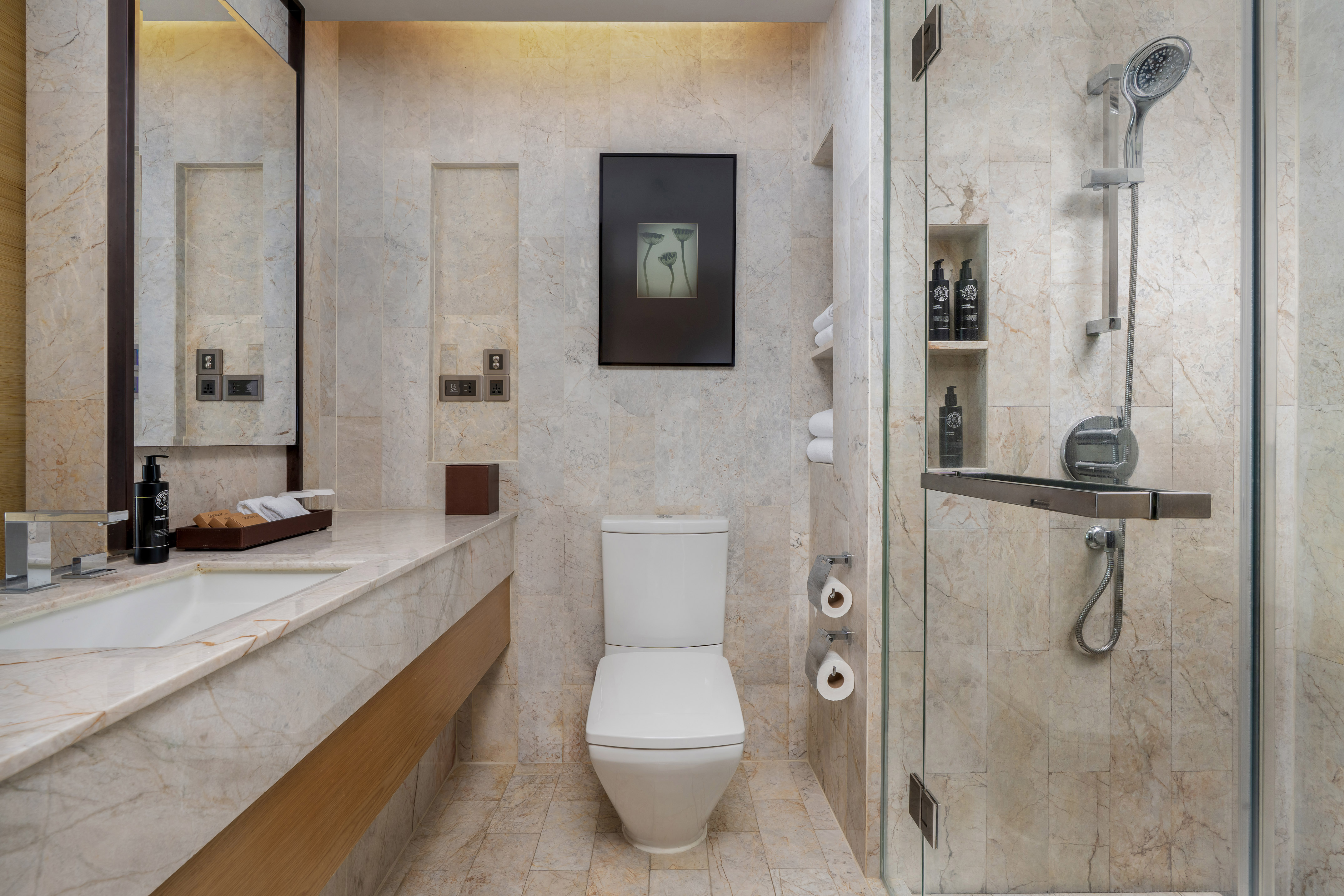 Modern marble bathroom featuring a white toilet, sink vanity, and glass shower. - Guest Room - The Hotel Bangkok Sukhumvit 26 Affiliated by Meliá, بانكوك