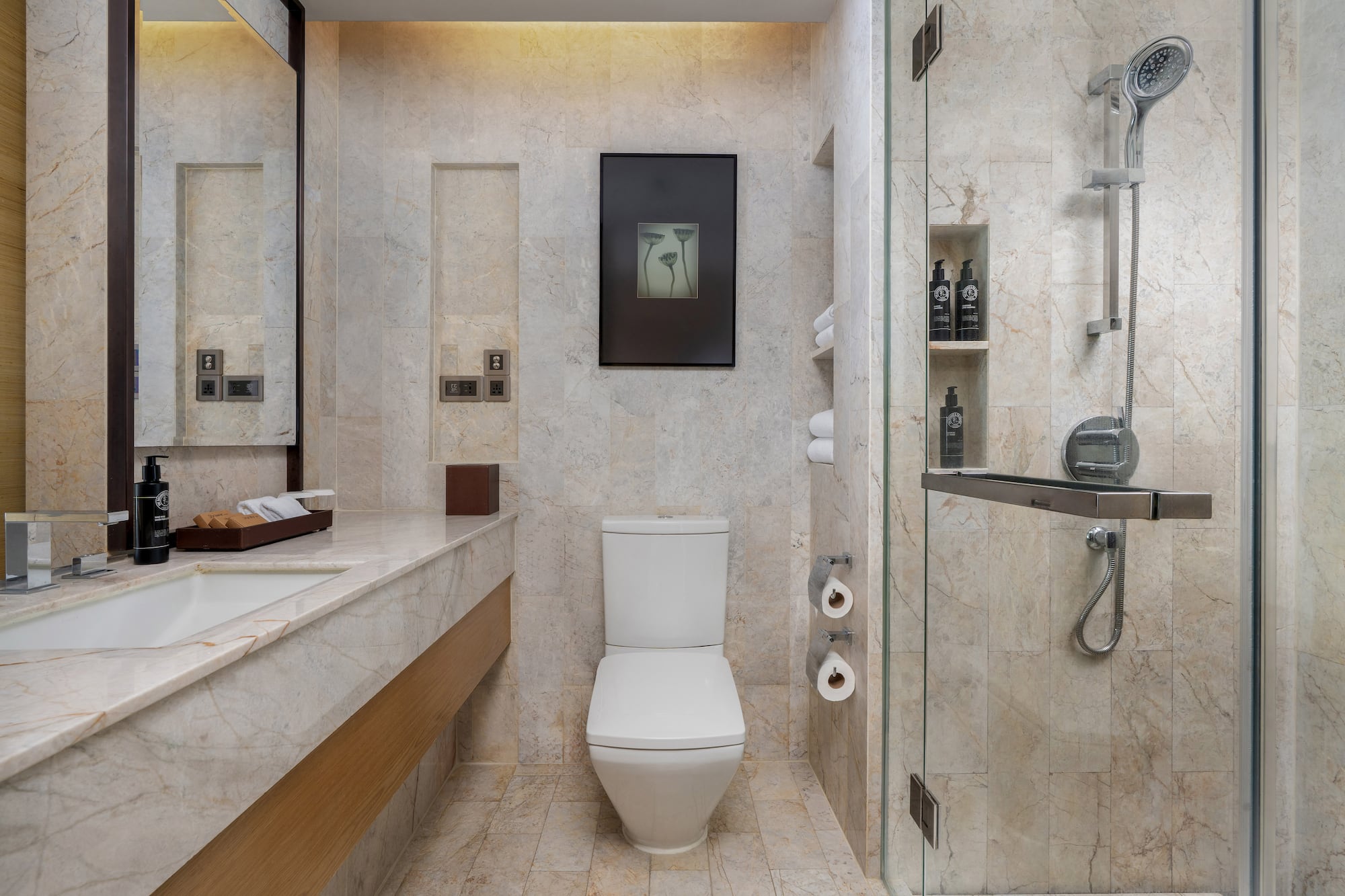 Modern marble bathroom featuring a white toilet, sink vanity, and glass shower. - Guest Room - The Hotel Bangkok Sukhumvit 26 Affiliated by Meliá, Bangkok