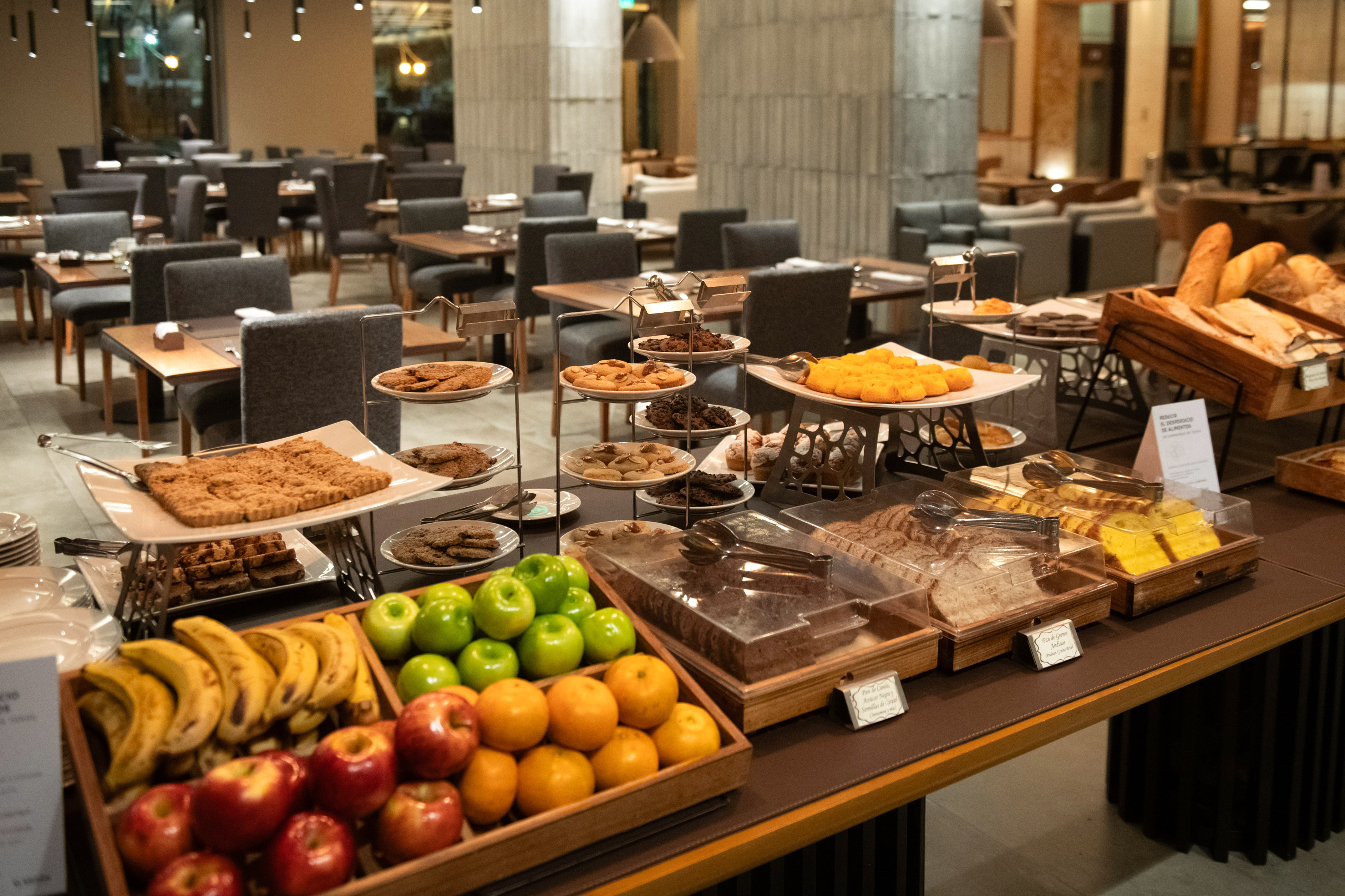 Hotel breakfast buffet with fresh fruit, pastries, cookies, and bread.