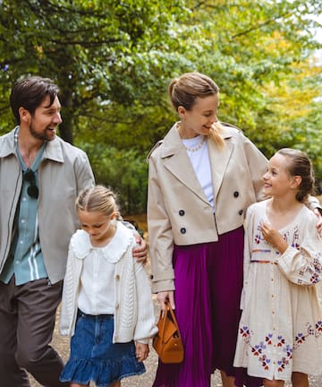 a man and woman walking with two girls