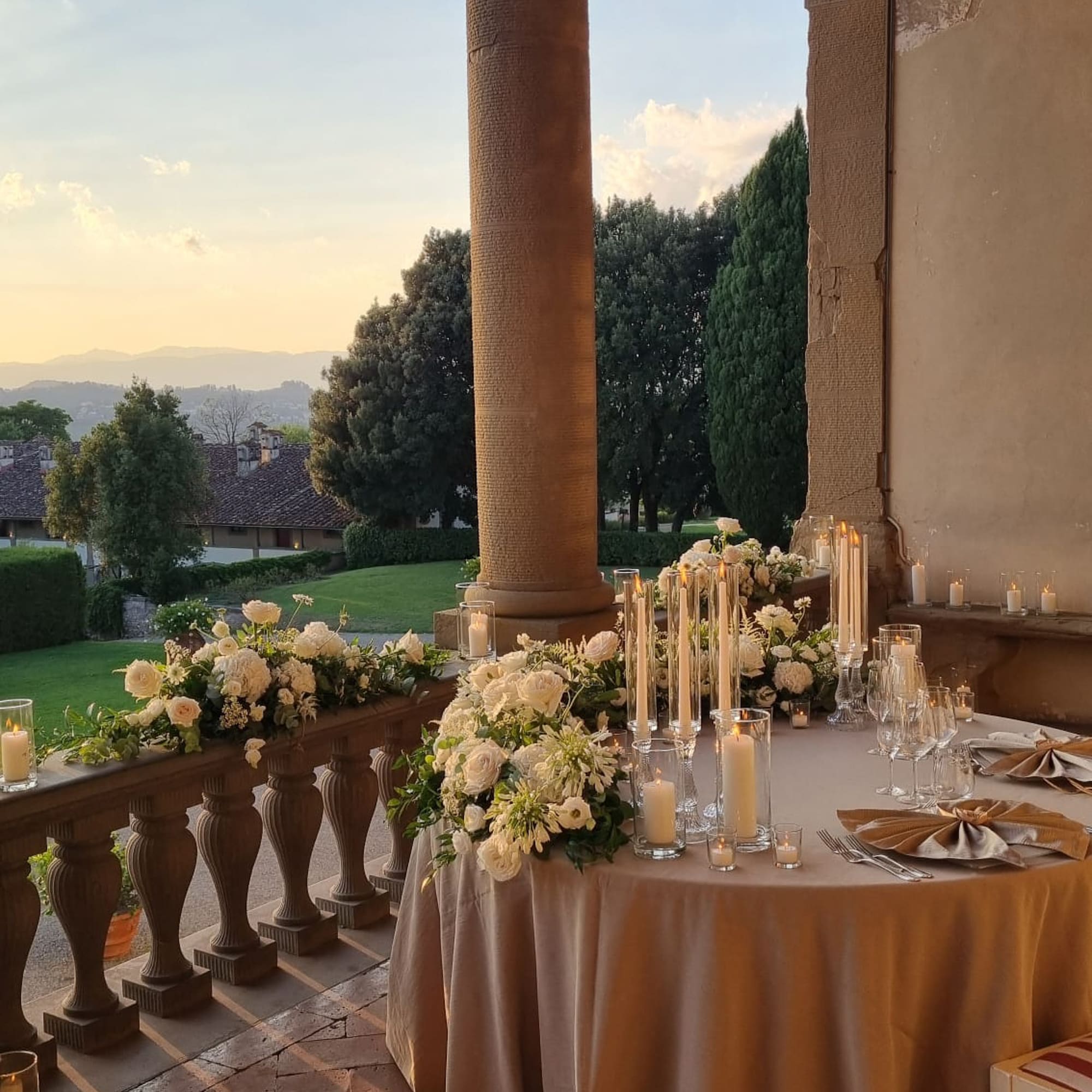 a table set up with candles and flowers on it