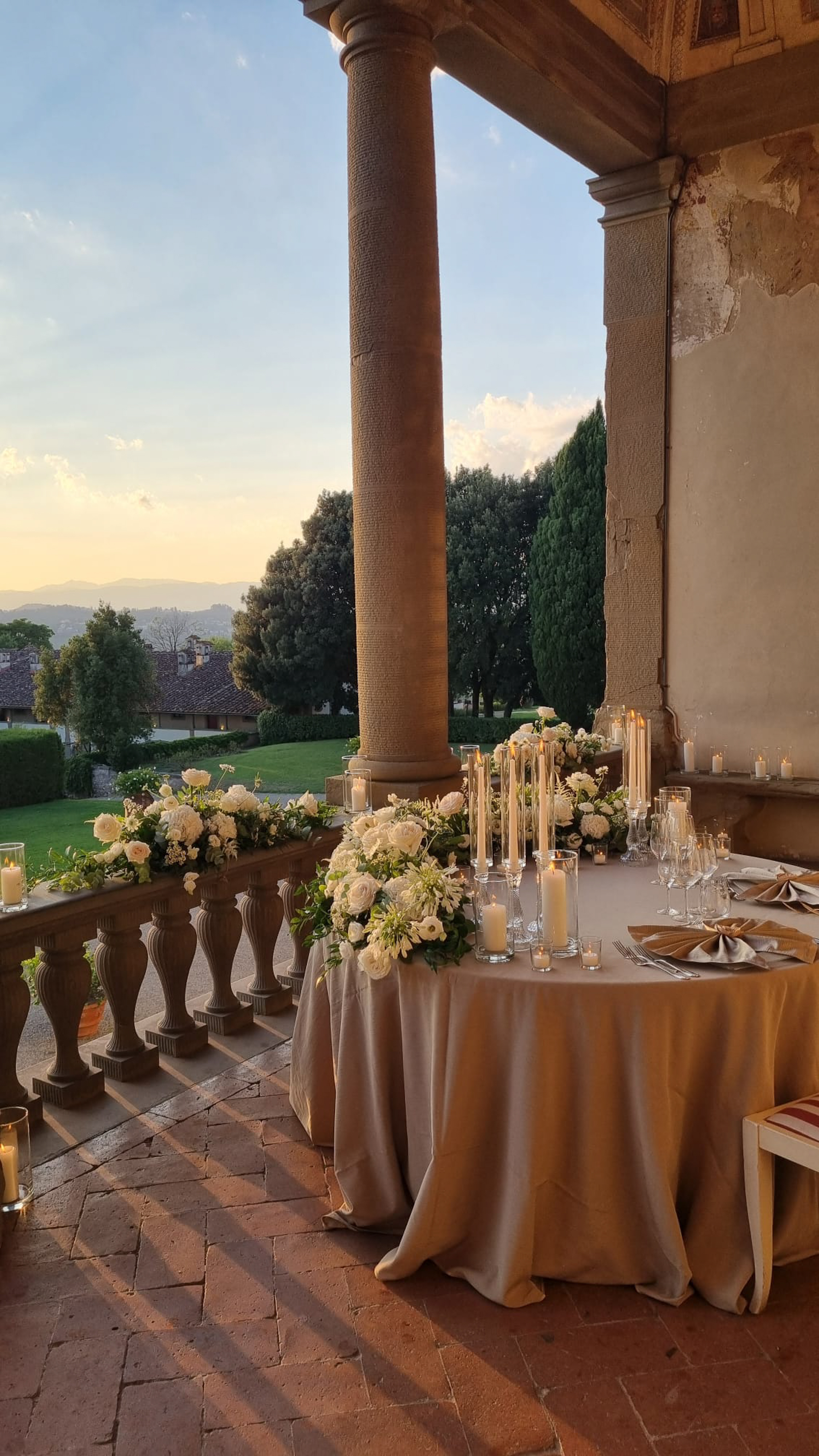 a table set up with candles and flowers on it