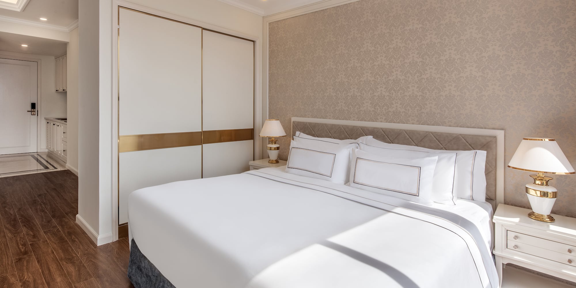 a bed with white sheets and pillows in a room