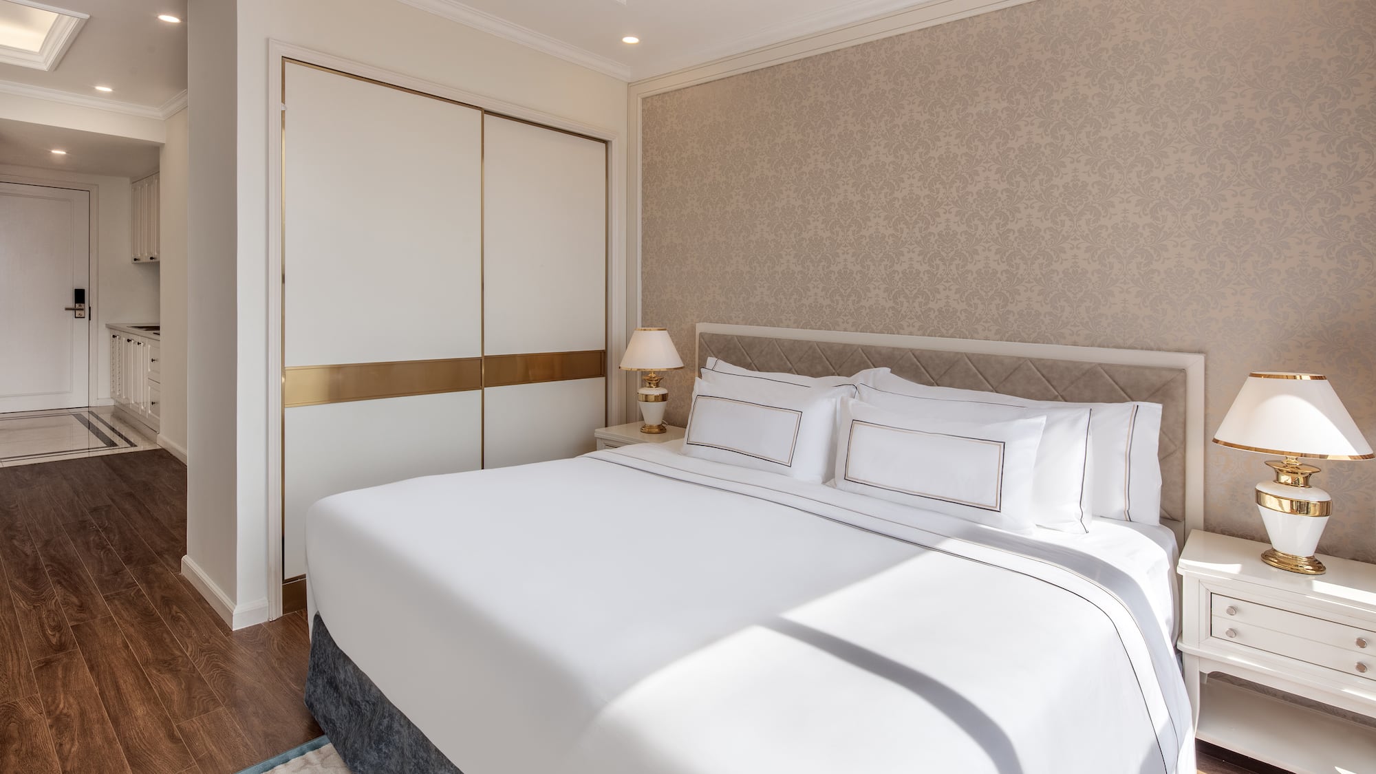 a bed with white sheets and pillows in a room