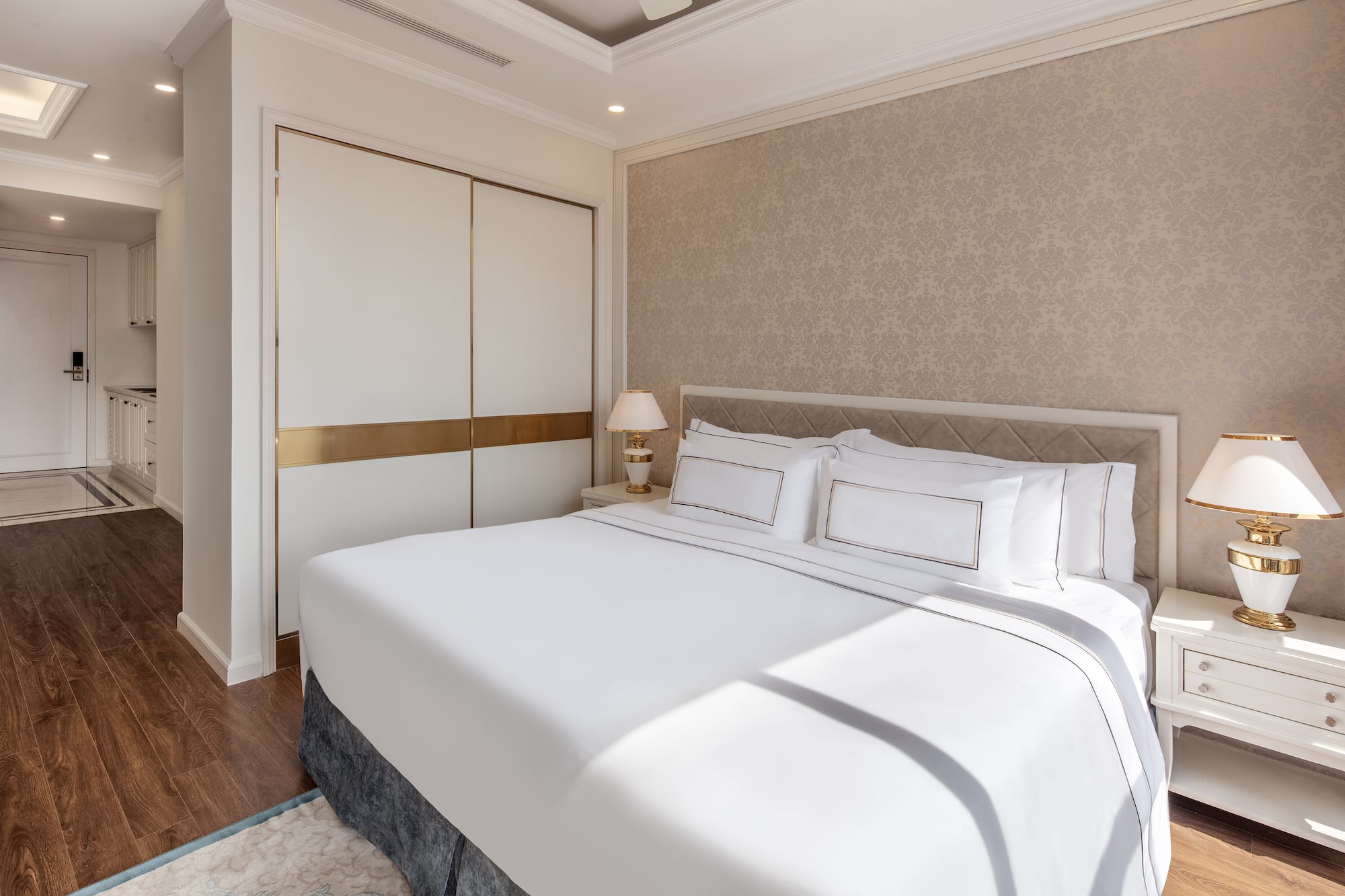 a bed with white sheets and pillows in a room