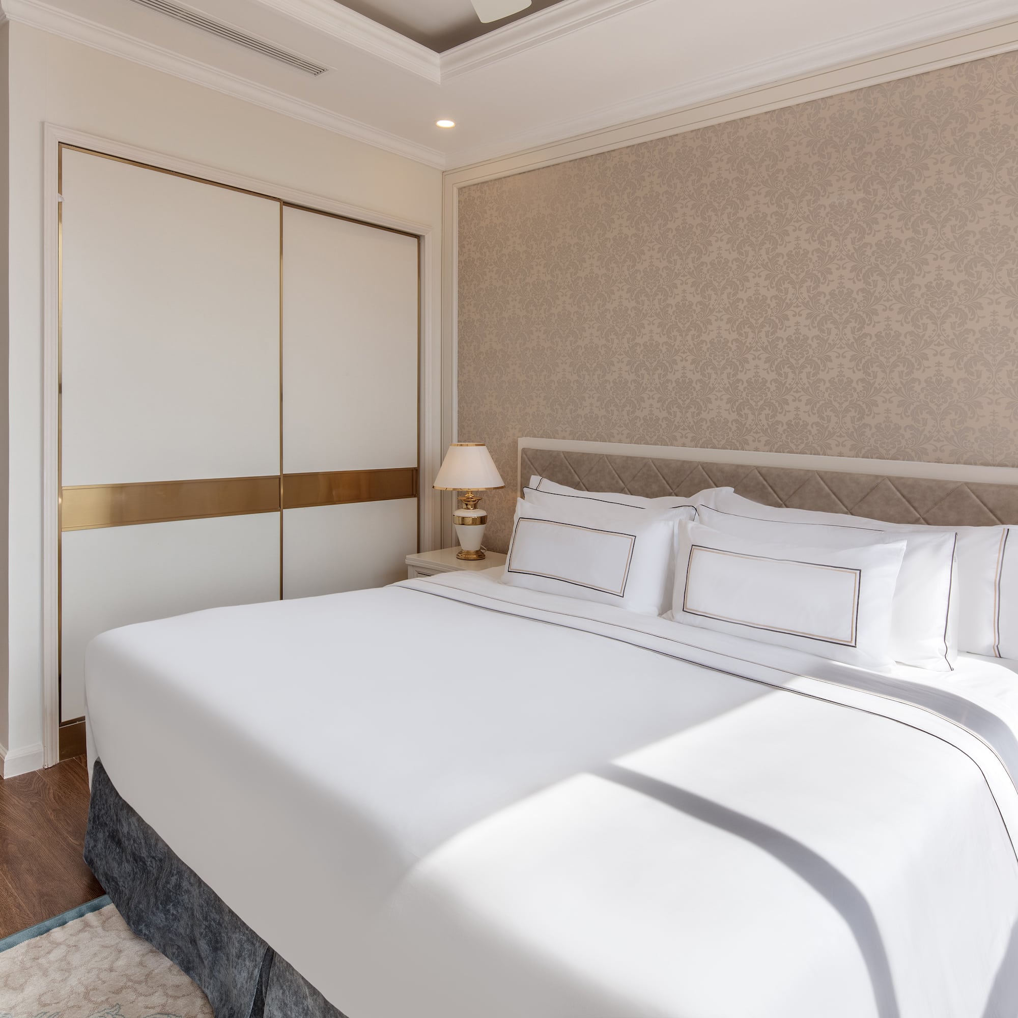 a bed with white sheets and pillows in a room