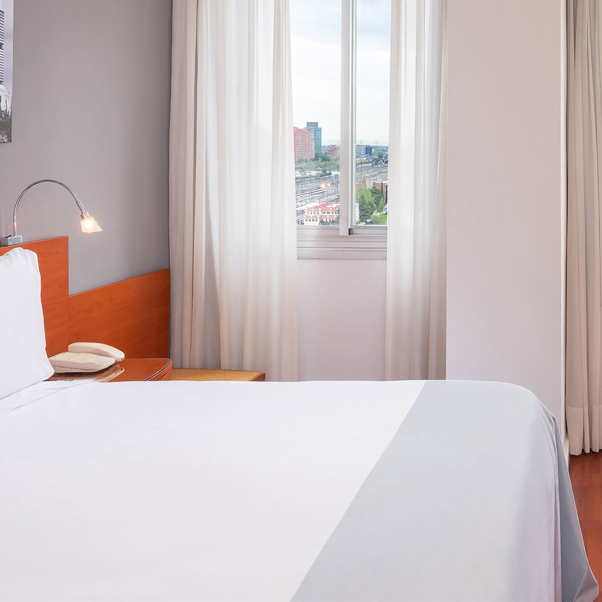 a bed with white sheets and a lamp