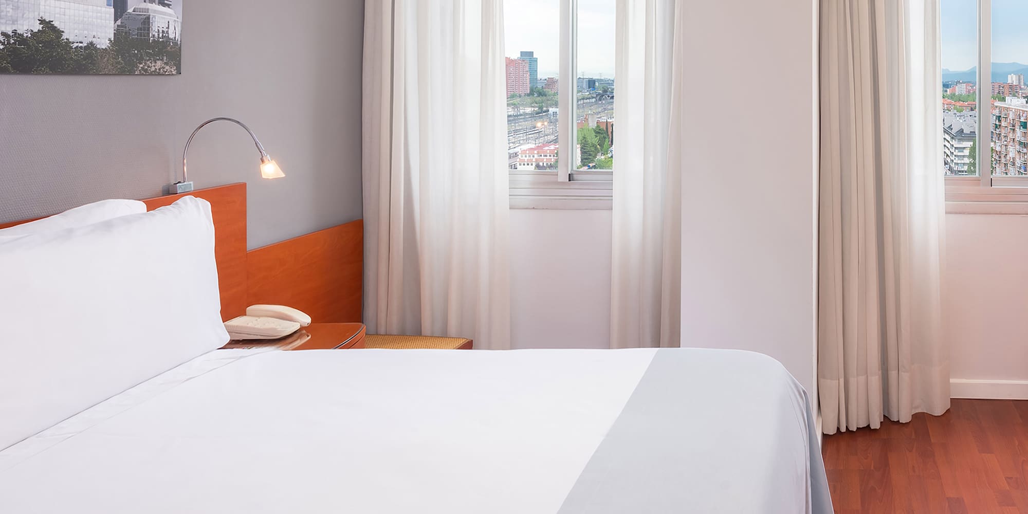 a bed with white sheets and a lamp