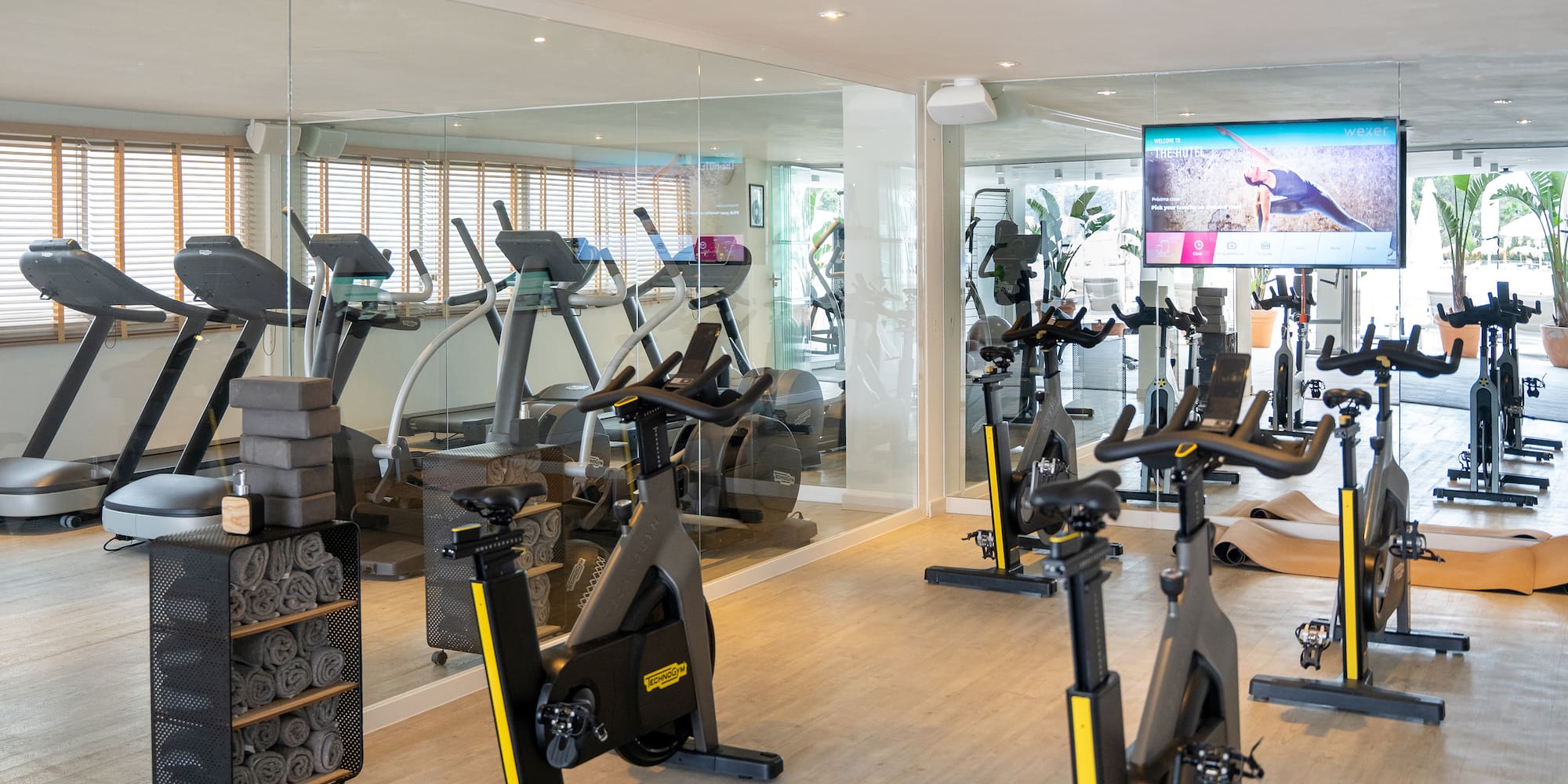 a room with exercise bikes and a large screen
