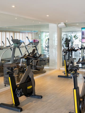 a room with exercise bikes and a large screen