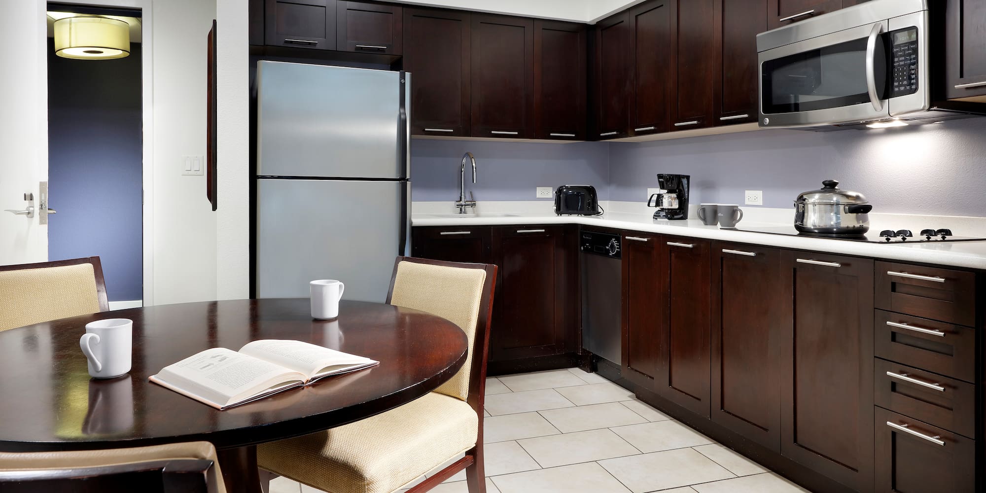 a kitchen with dark cabinets and a table