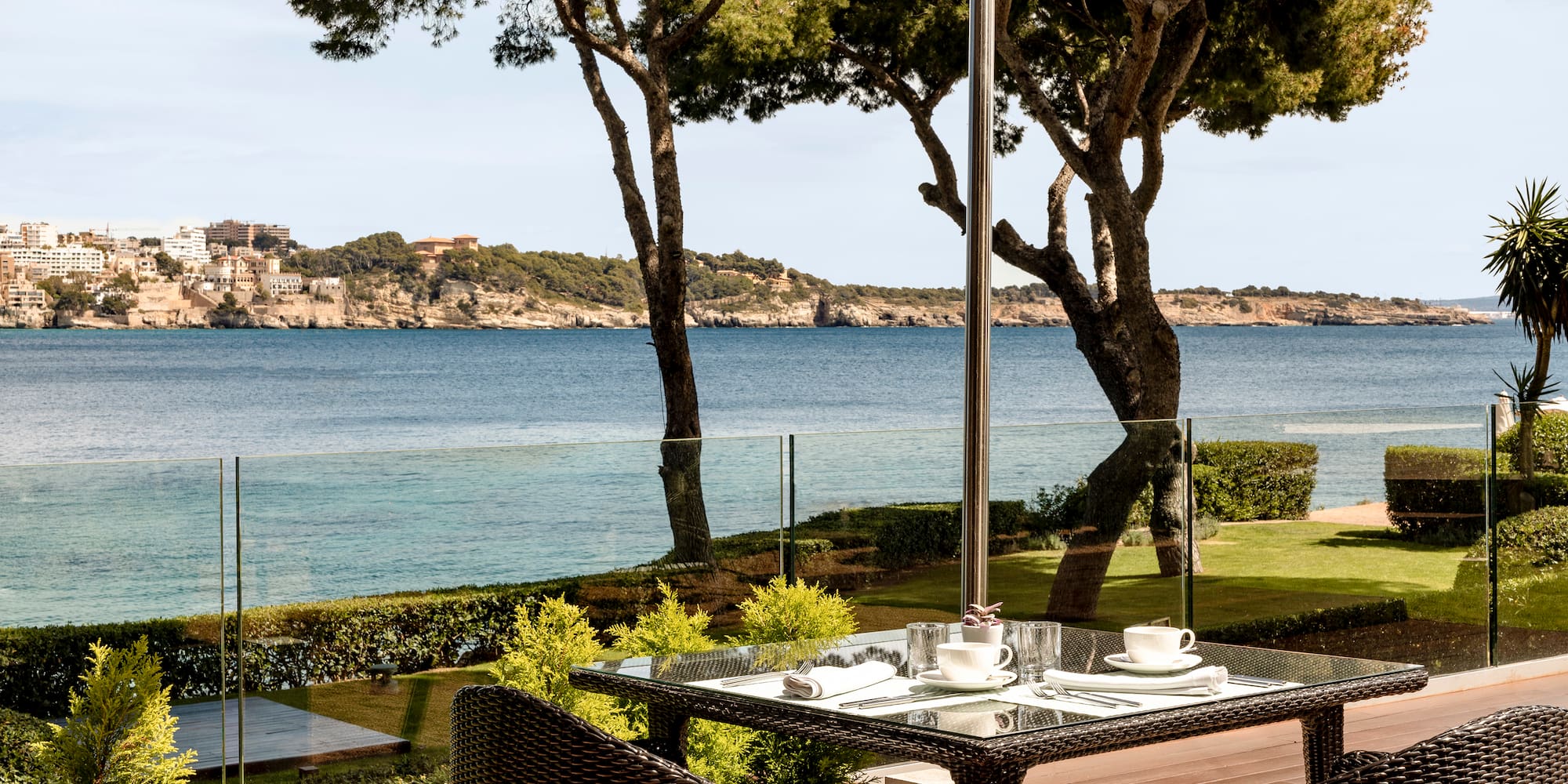a table and chairs with a view of the ocean