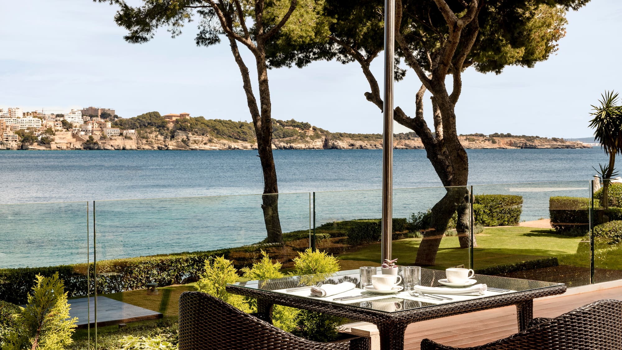 a table and chairs with a view of the ocean