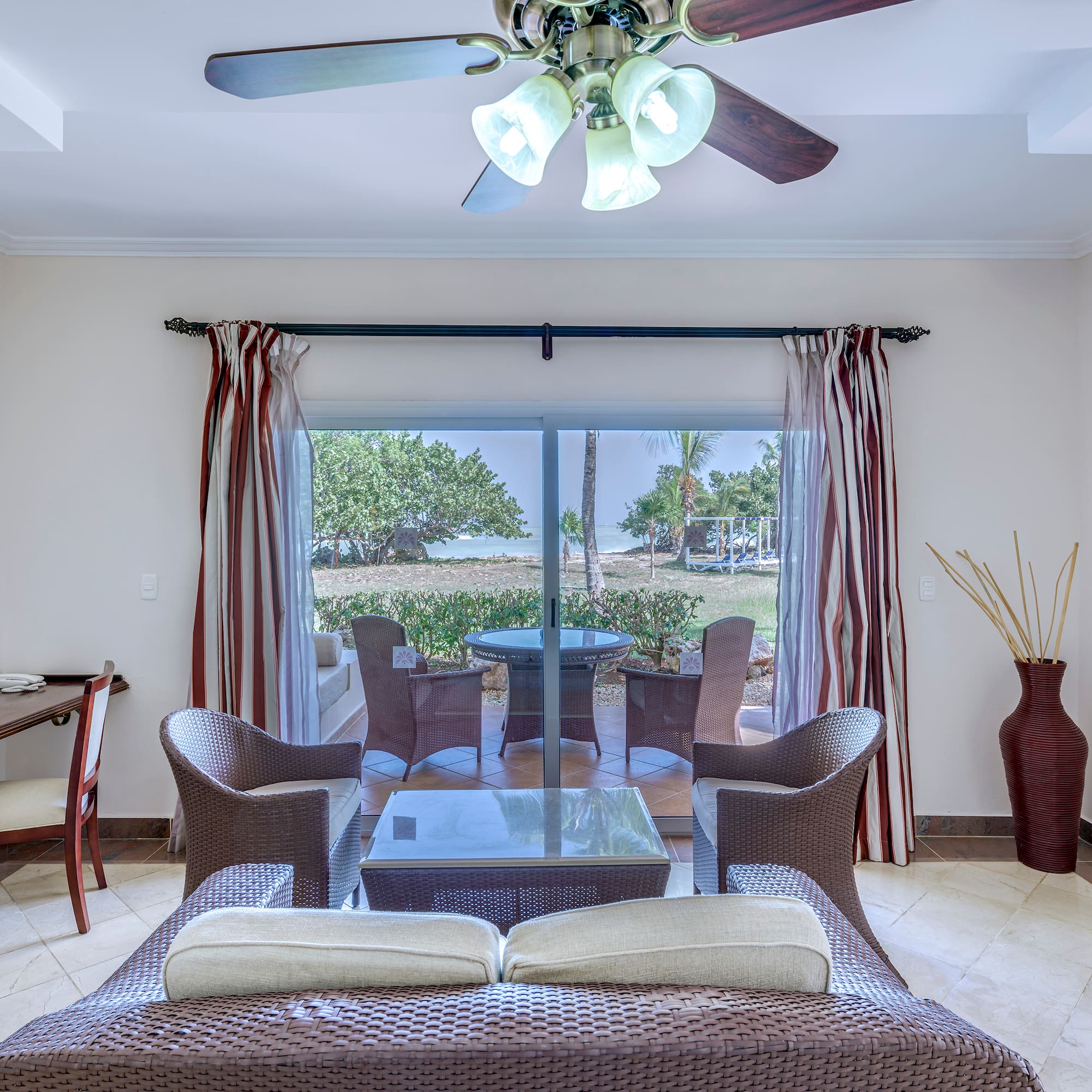a living room with a fan and chairs
