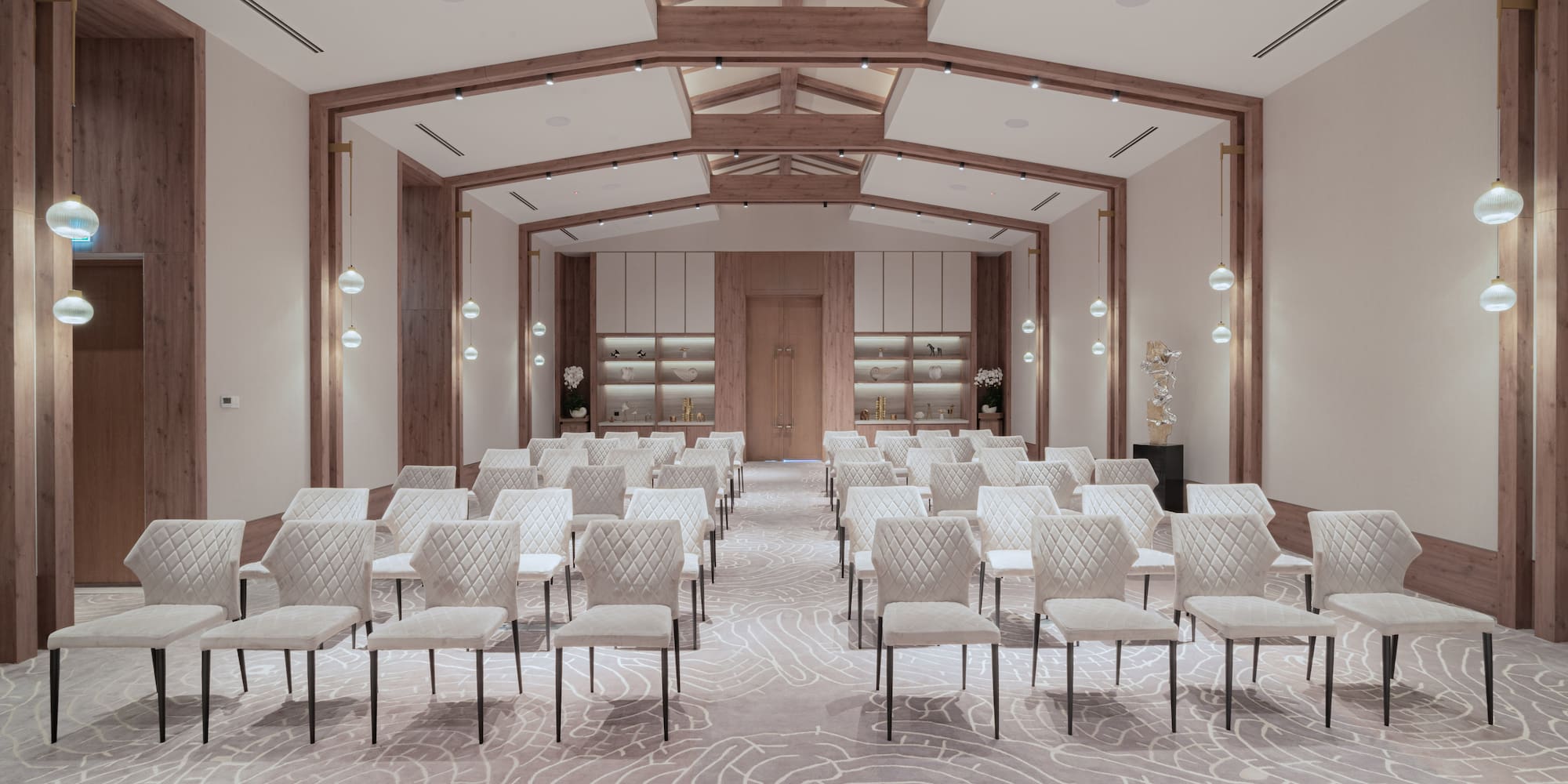 a room with white chairs and a light colored carpet